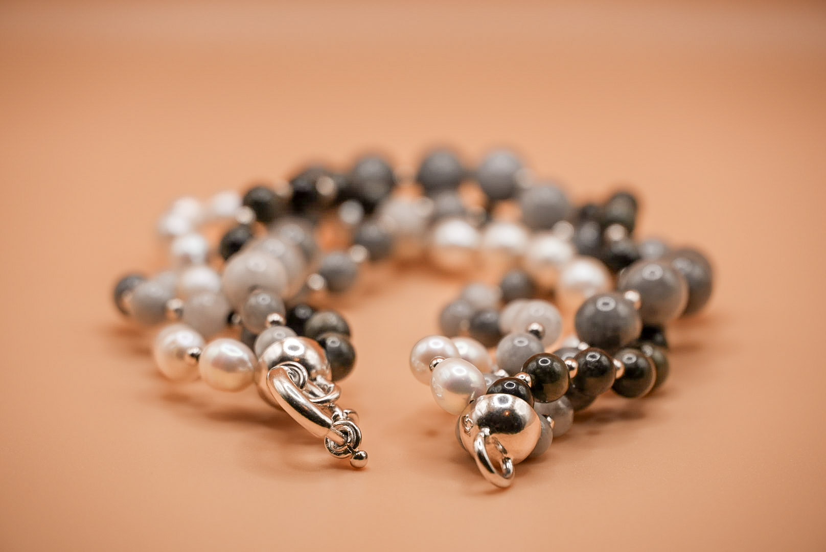 Bracciale rodiato multifilo in argento 925 con pietre (occhio d’aquila, perla ed ematite)