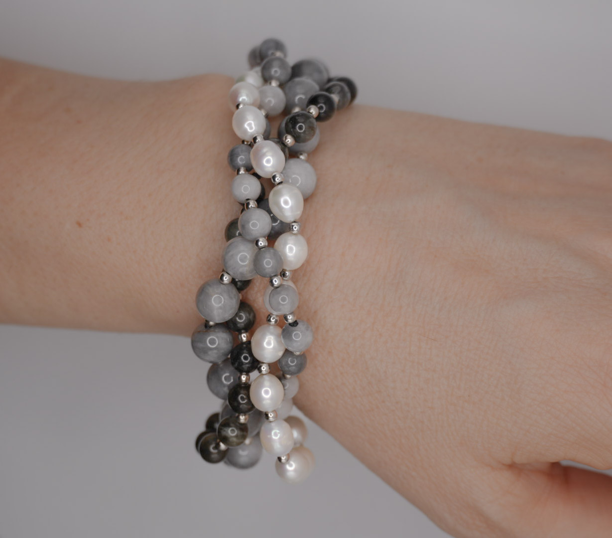 Bracciale rodiato multifilo in argento 925 con pietre (occhio d’aquila, perla ed ematite)