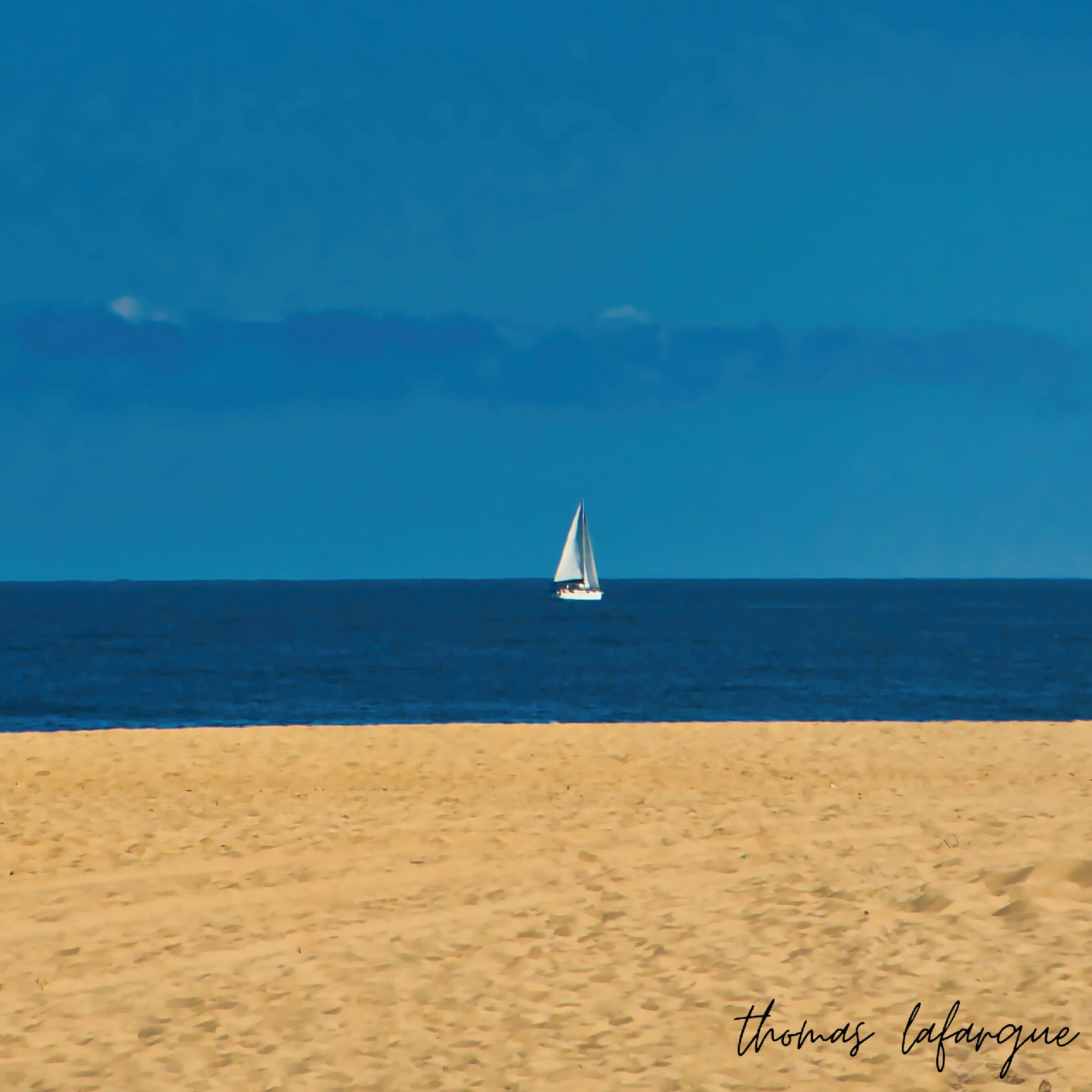 Photographie de plage avec voilier