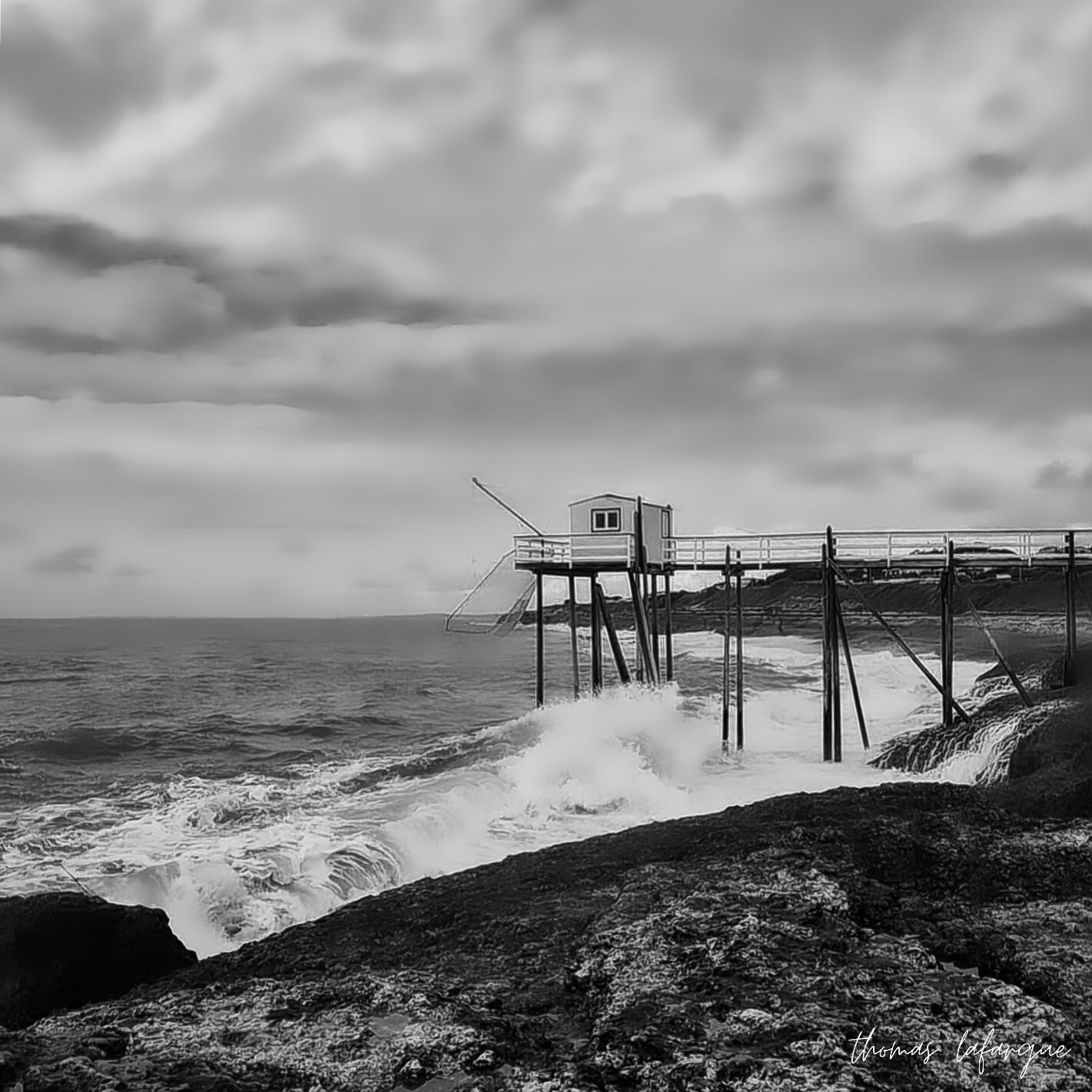 Photographie en noir et blanc d'une cabane de pêche