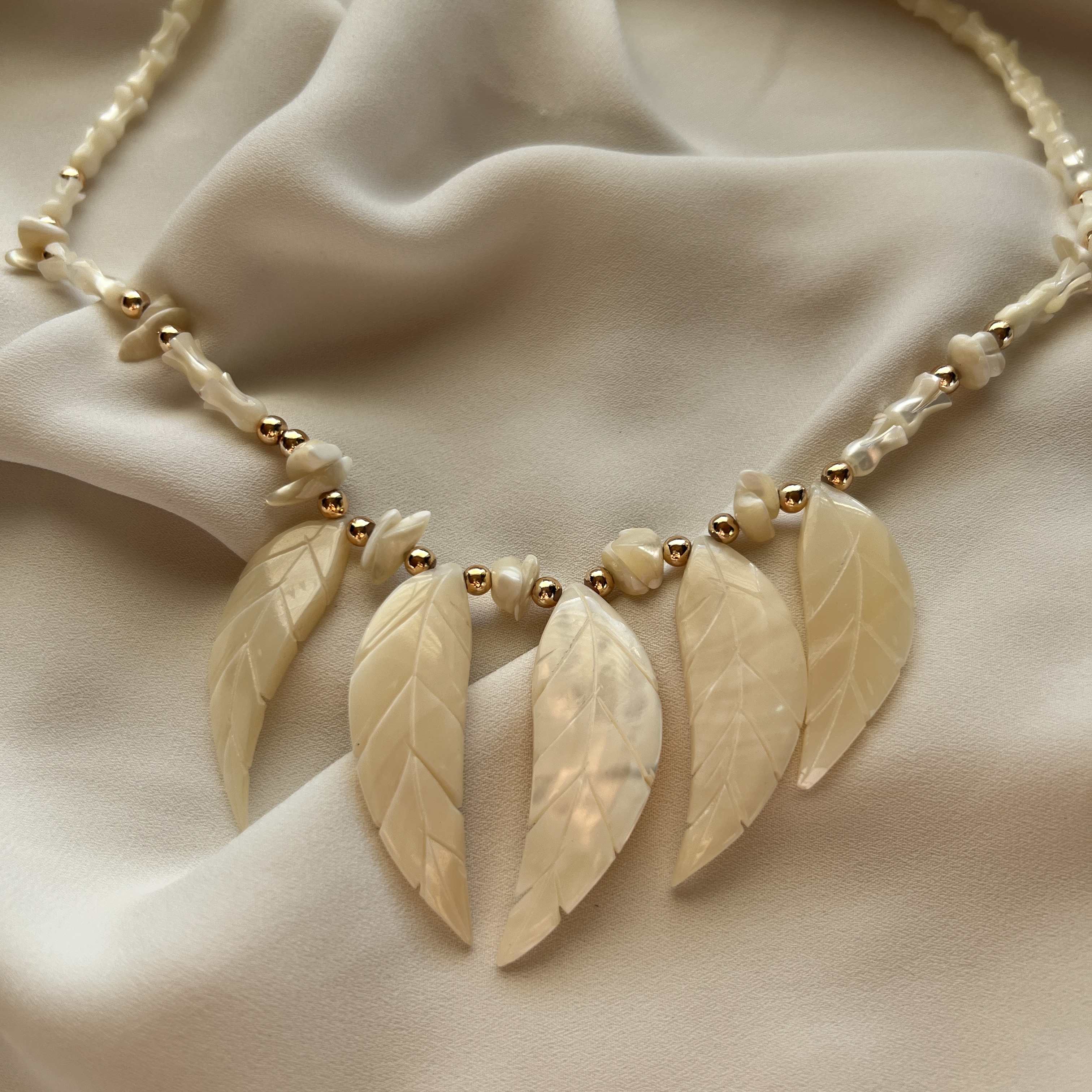 Kaklo papuošalas su kriauklės lapeliais