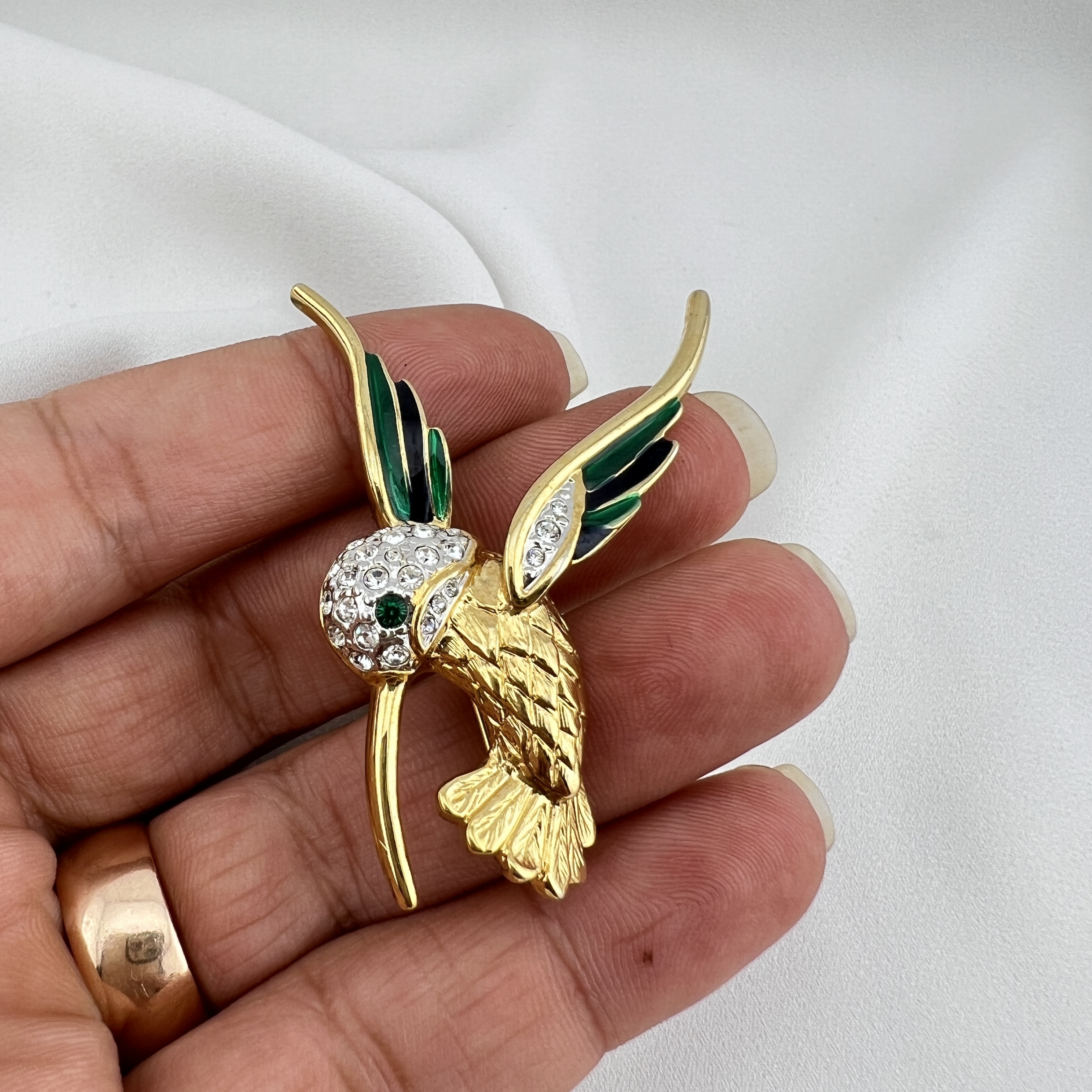 Vintažinė kolibrio sagė – smaragdinis spindesys ir judesio elegancija