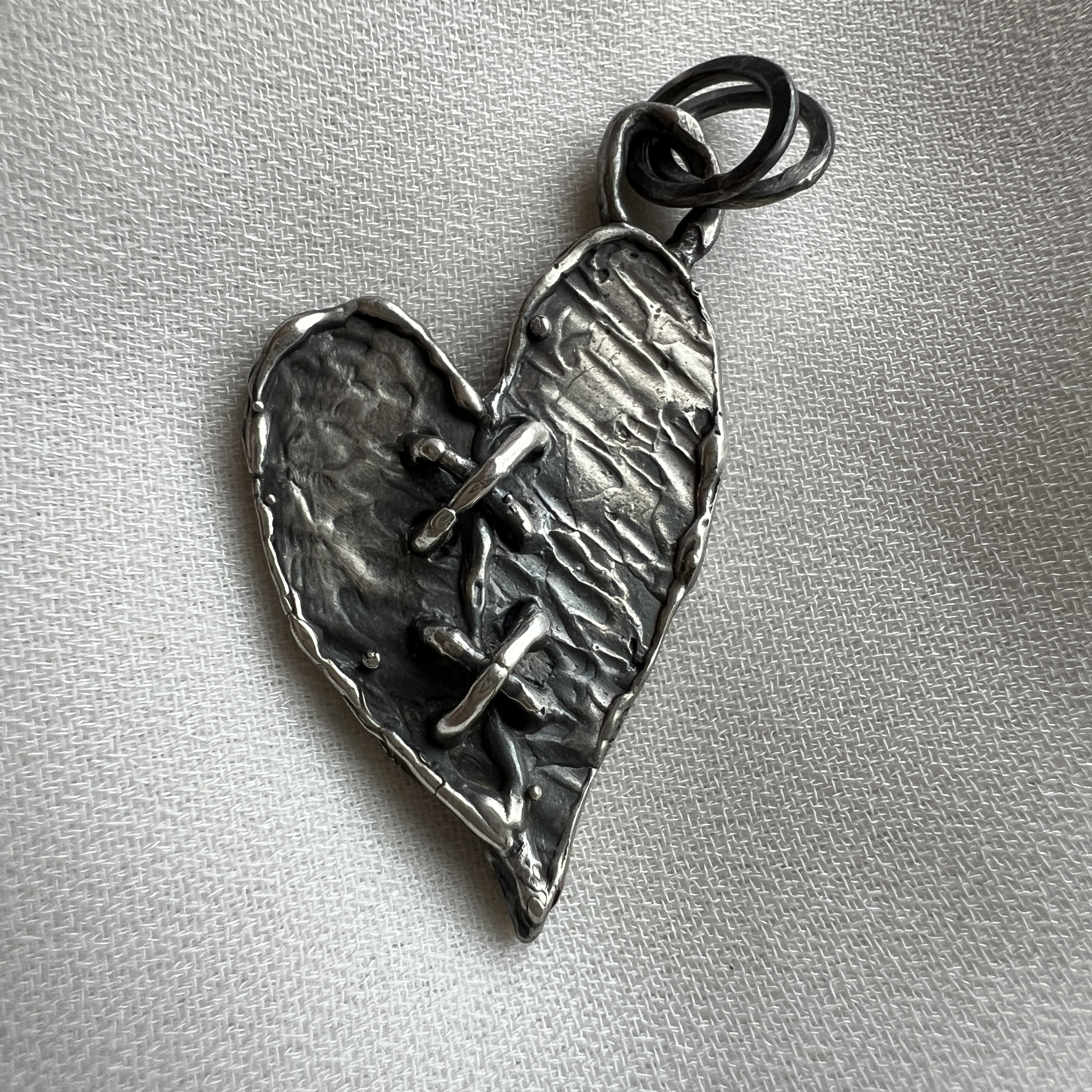 Rankų darbo sidabrinis „susiūtos širdies“ pakabukas