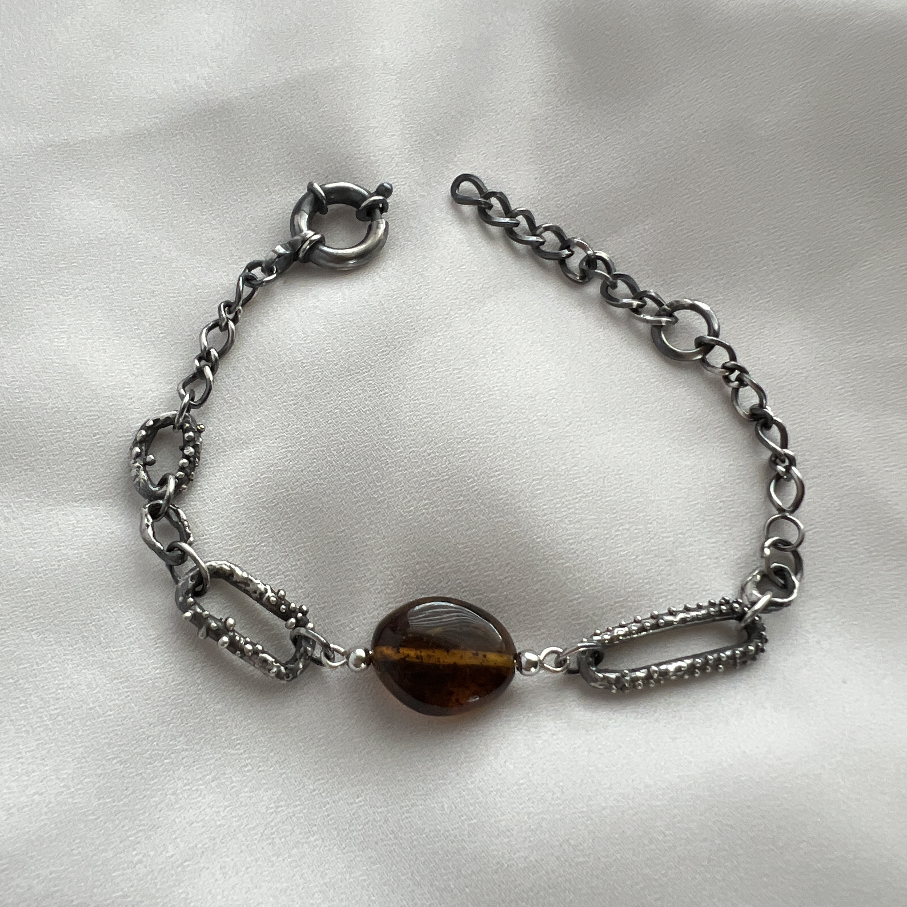 Rankų darbo oksiduoto sidabro apyrankė su gintaru