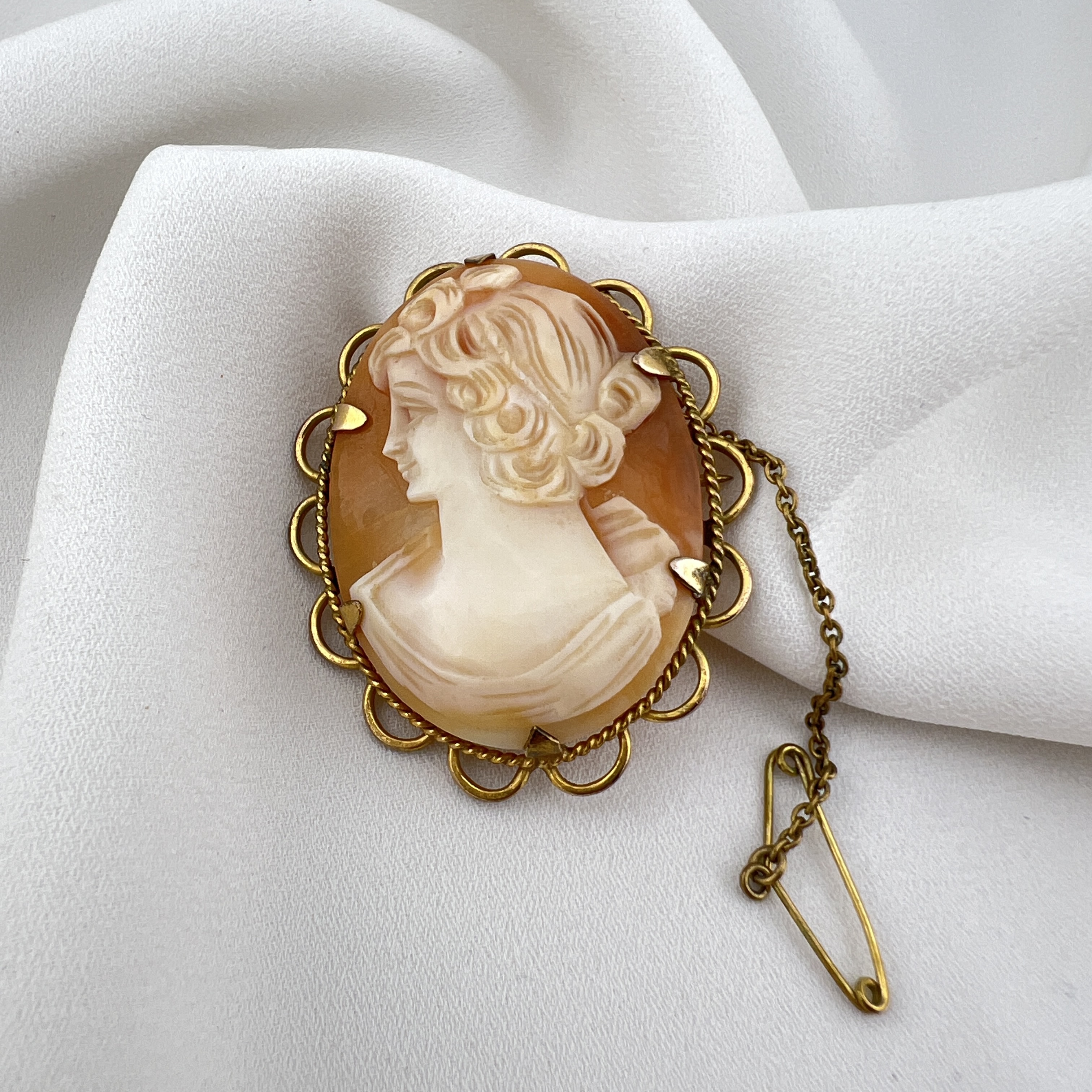 Klasikinė elegancija: Rankomis pjaustyta kriauklės kamėja (Rolled Gold)