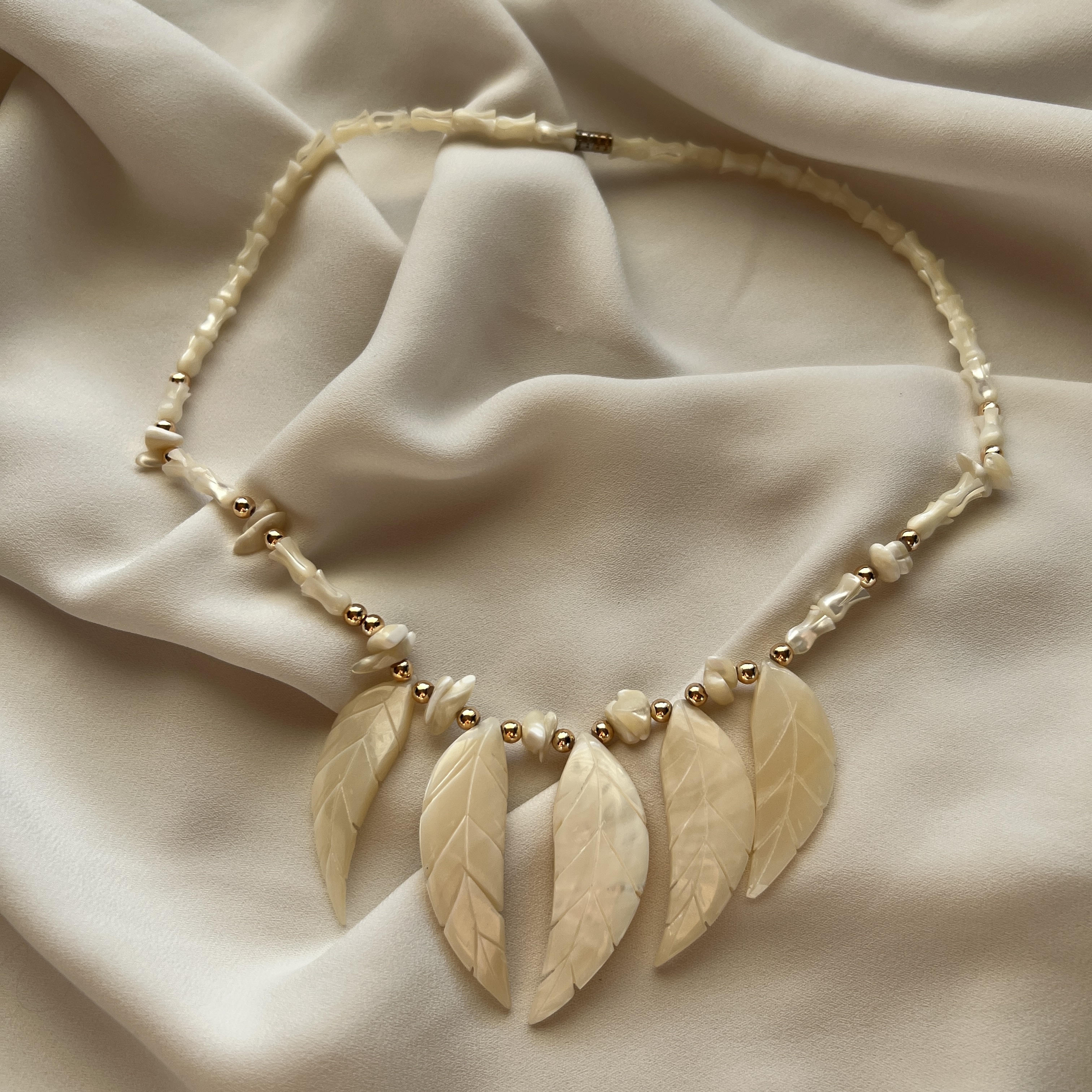 Kaklo papuošalas su kriauklės lapeliais