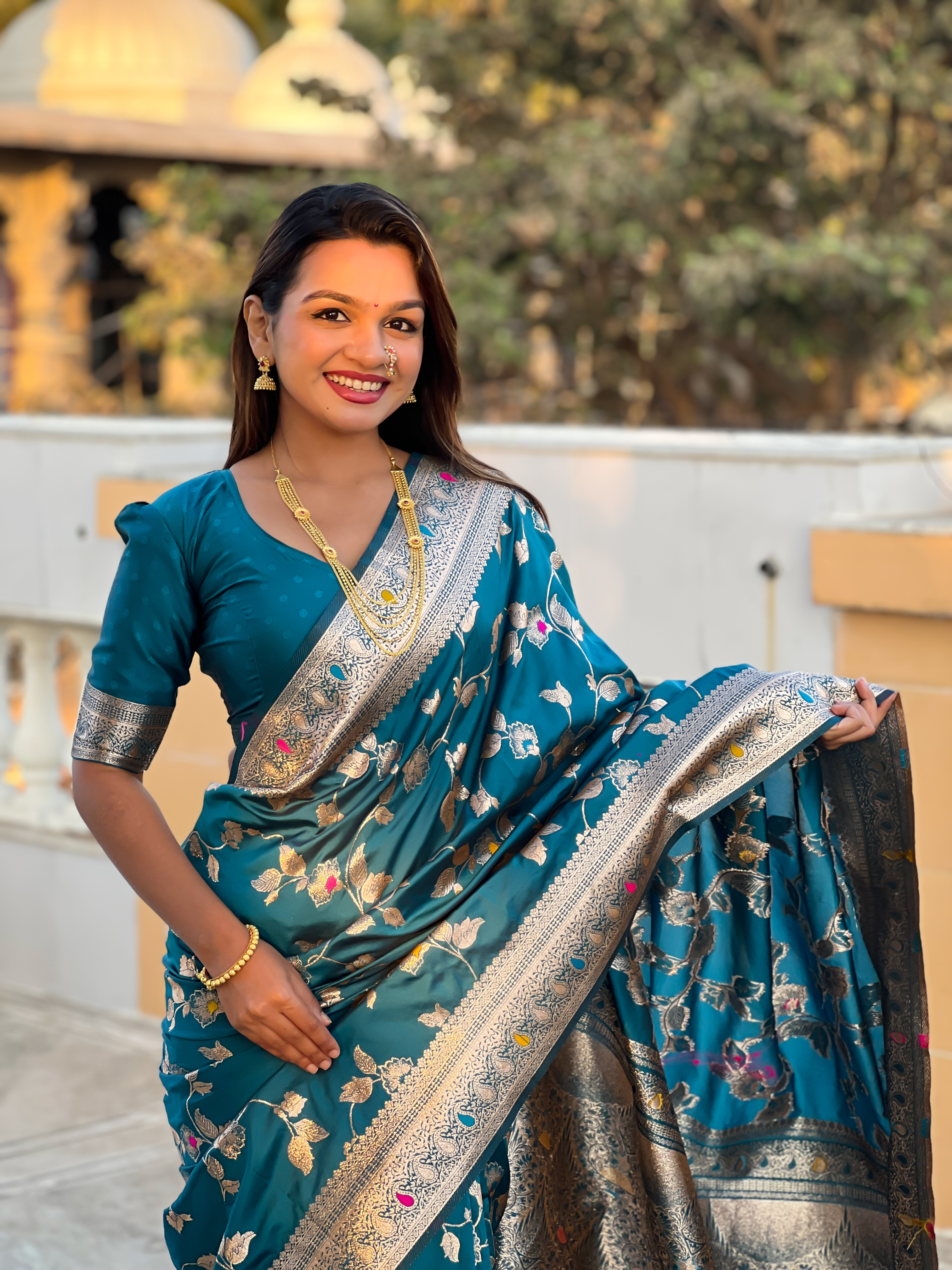 Immerse yourself in the vibrant charm of this turquoise blue Banarasi silk saree