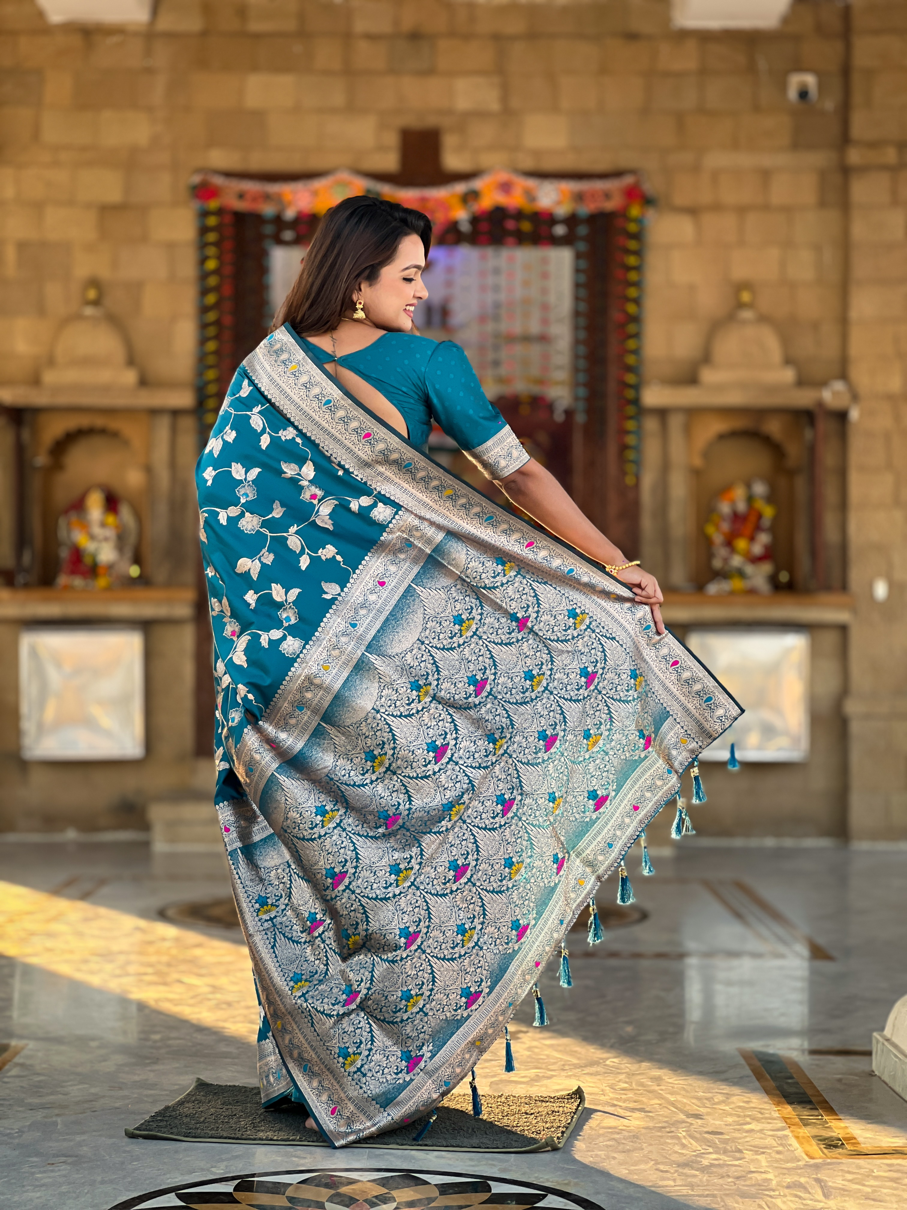 Immerse yourself in the vibrant charm of this turquoise blue Banarasi silk saree