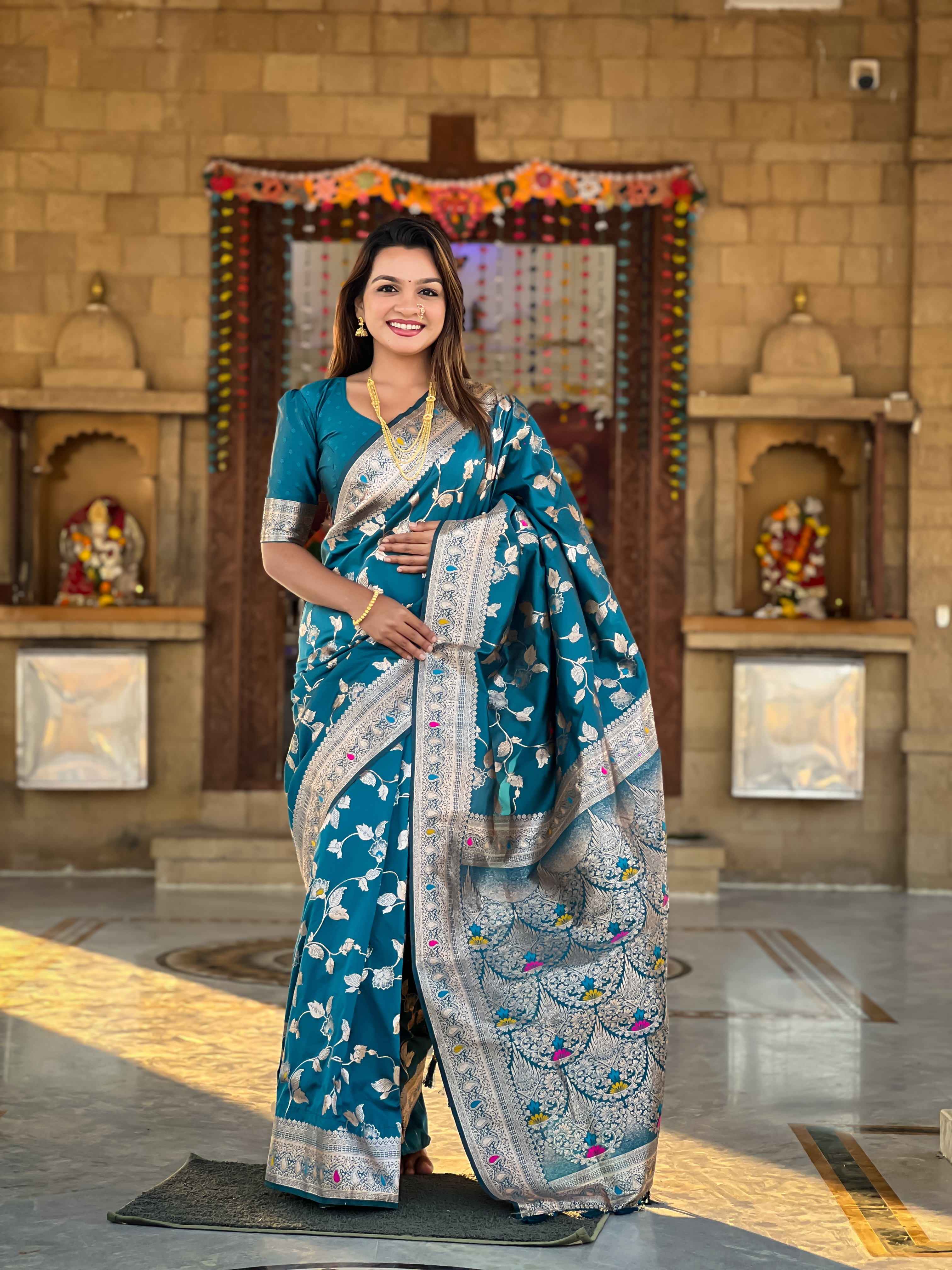 Immerse yourself in the vibrant charm of this turquoise blue Banarasi silk saree