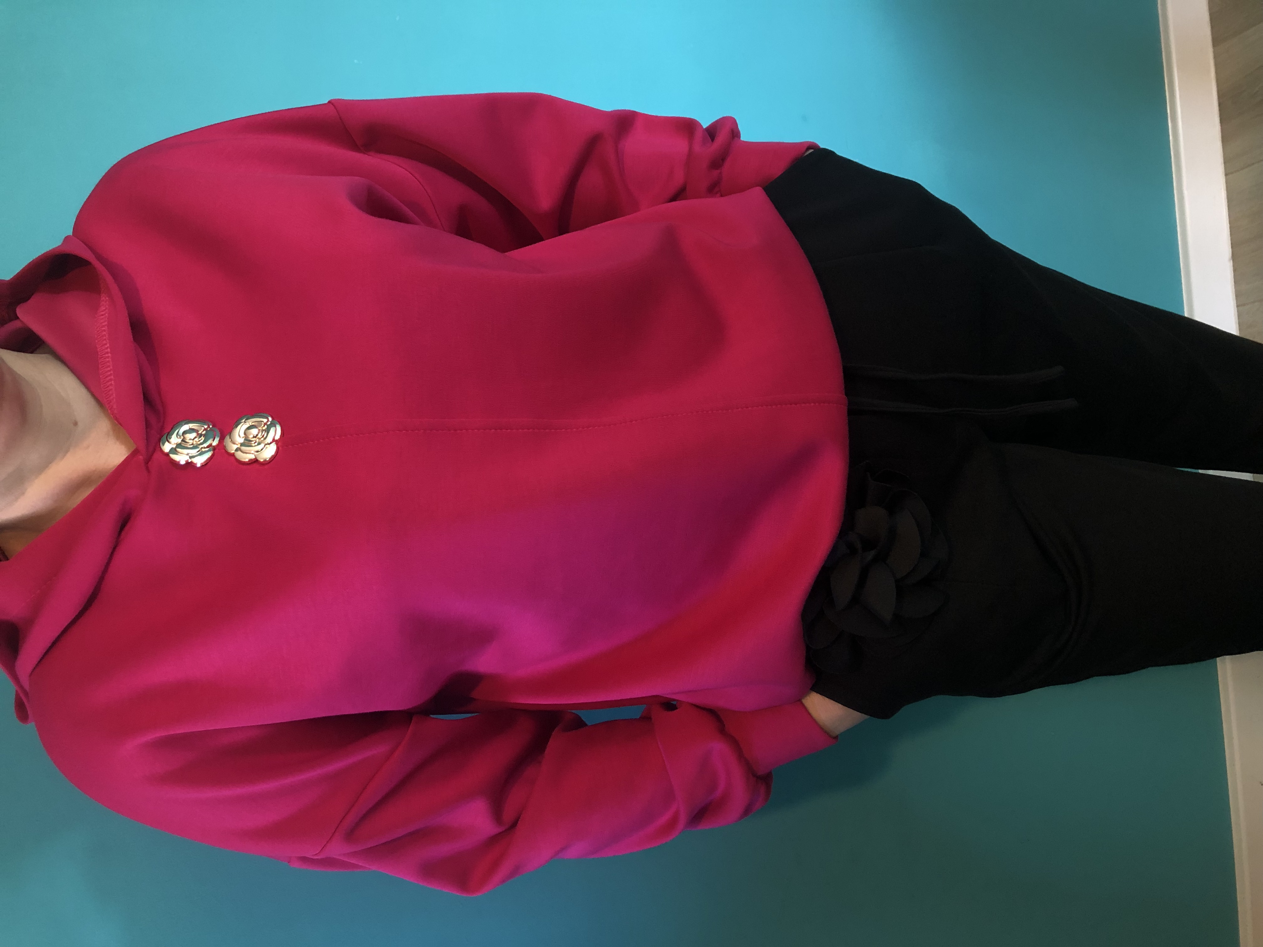 Różowa bluza z rękawami i czarnymi spodniami