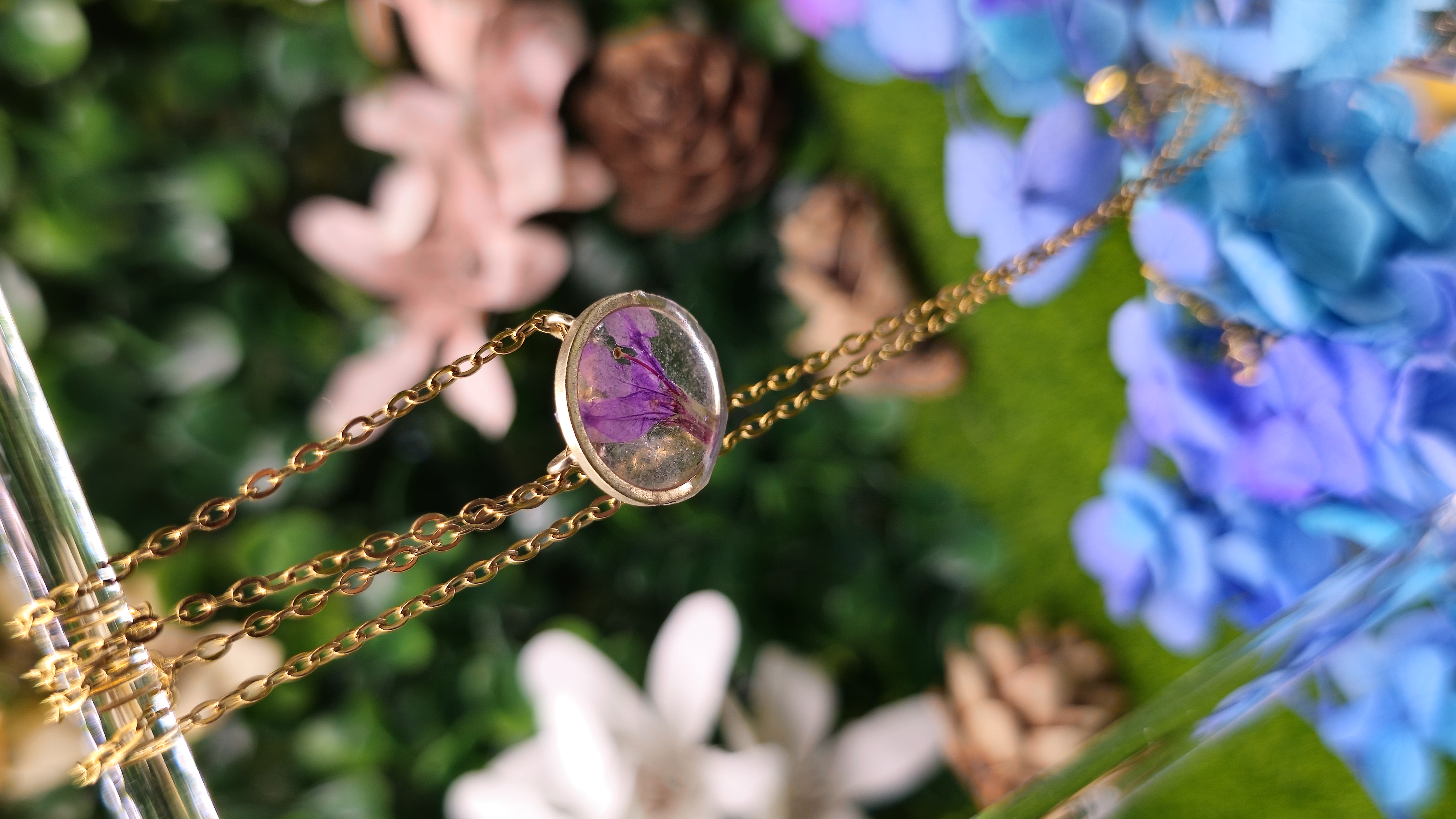 Colgante dorado con flor encapsulada