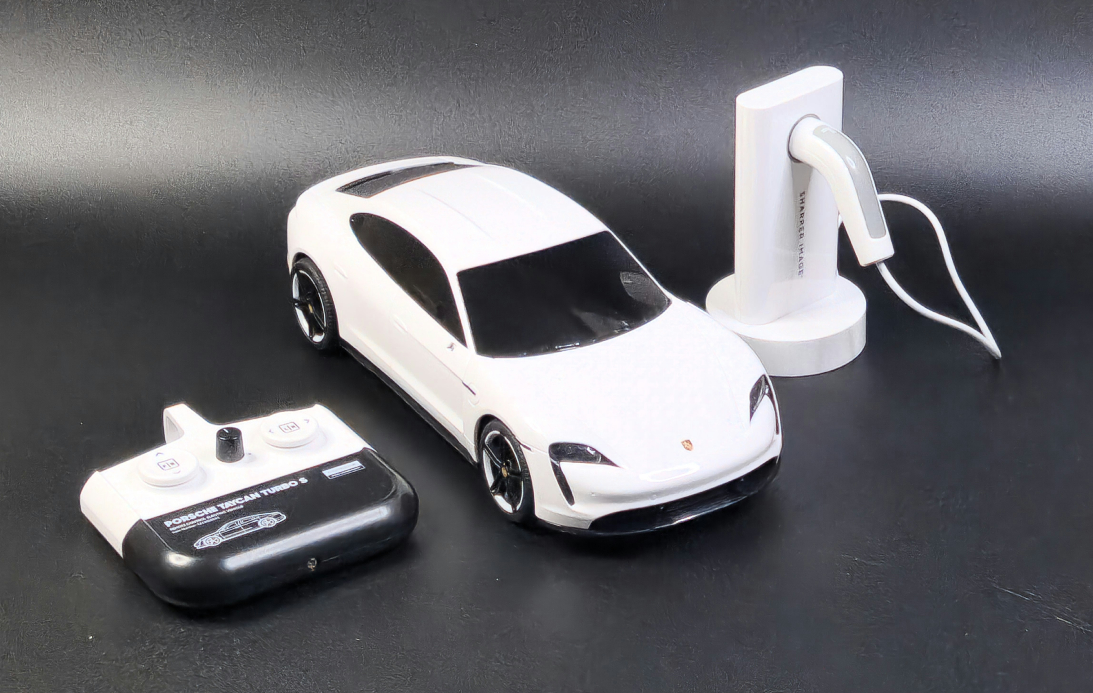 Nuotoliniu būdu valdomas automobilis „Porsche Taycan Turbo S“ su įkrovimo stotele