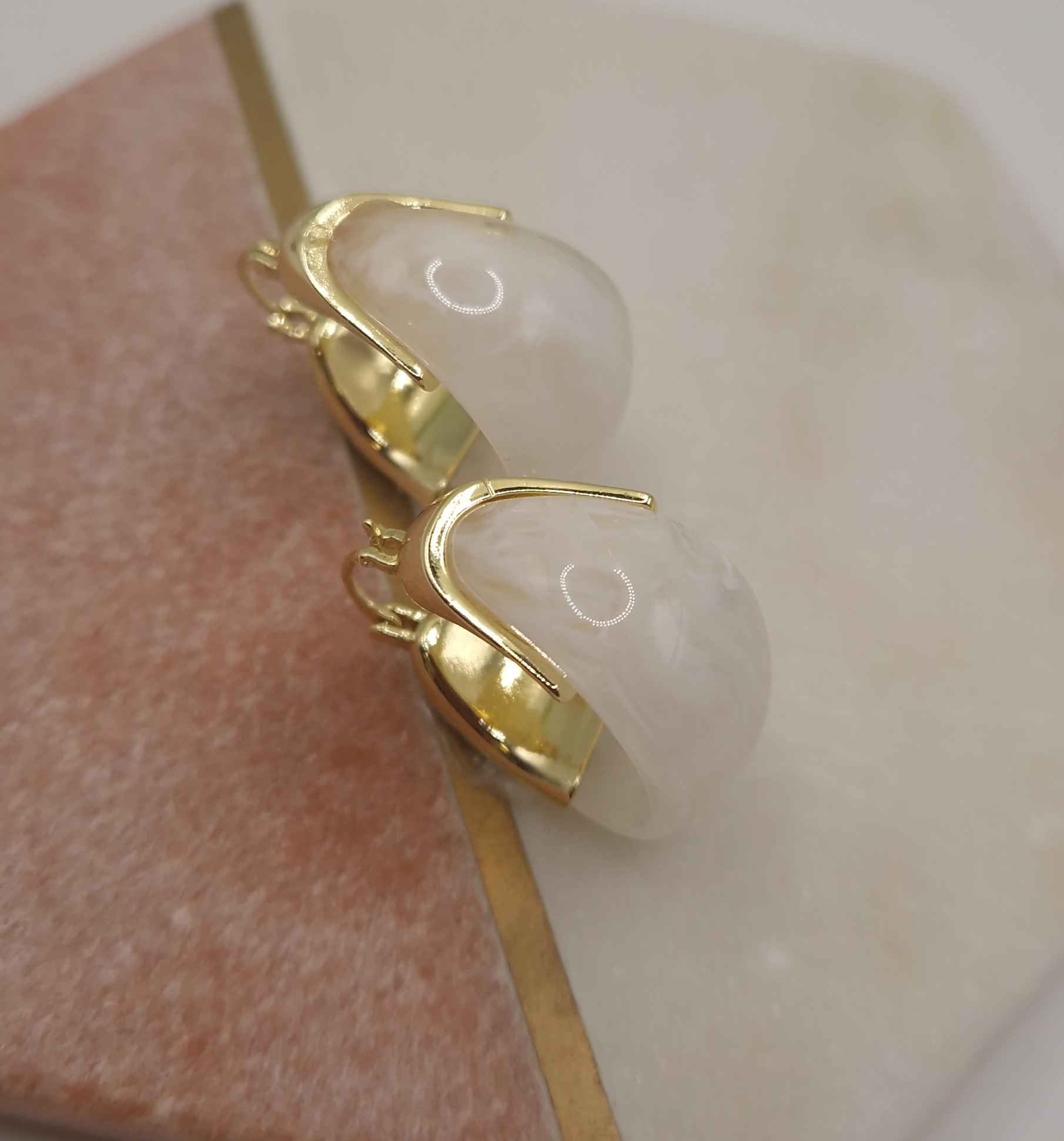 Earrings with an organic-shaped milky white stone