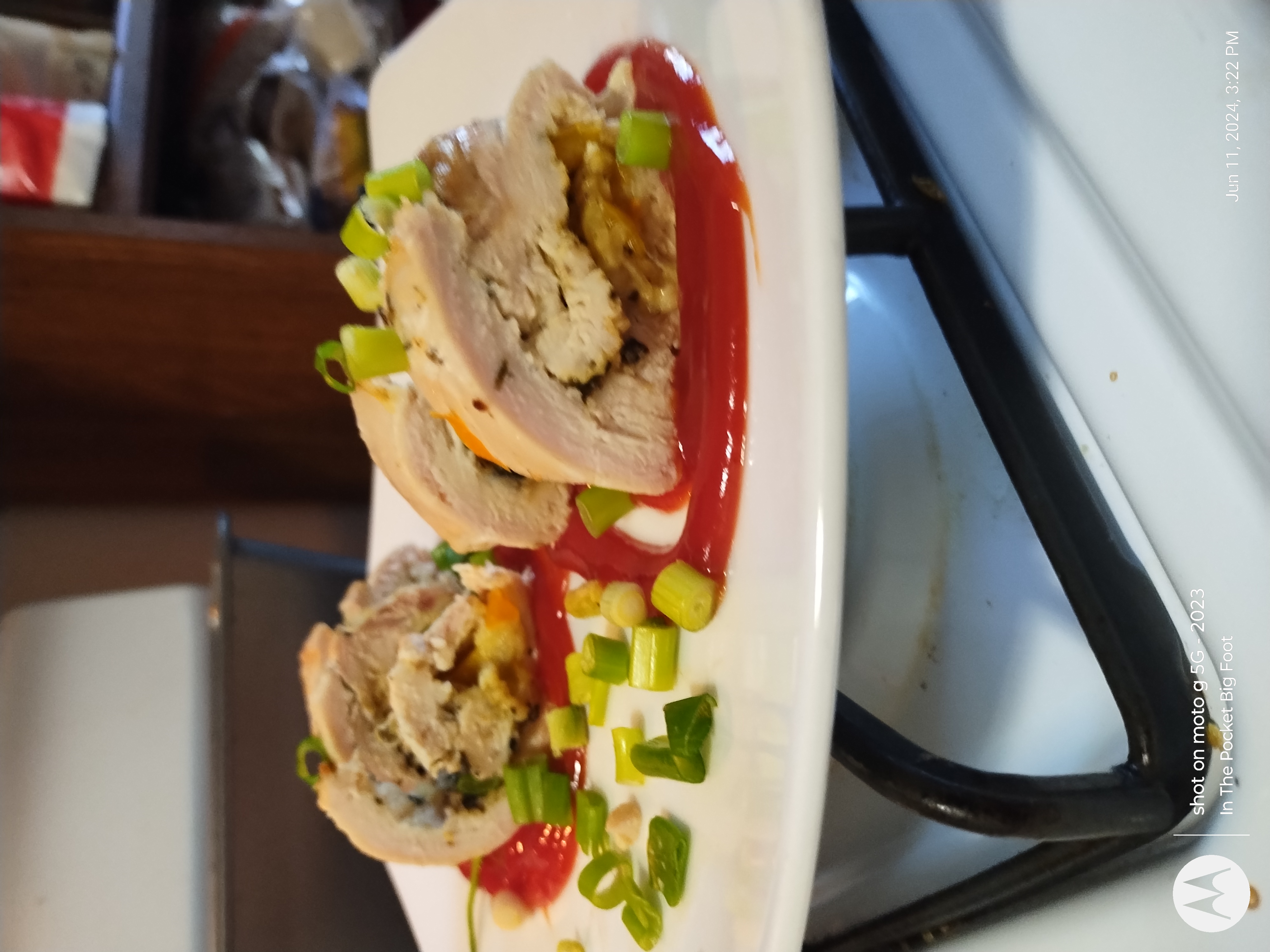 Chicken breasts wrapped in green peppers Little league with spring onions and ketchup for garnish
