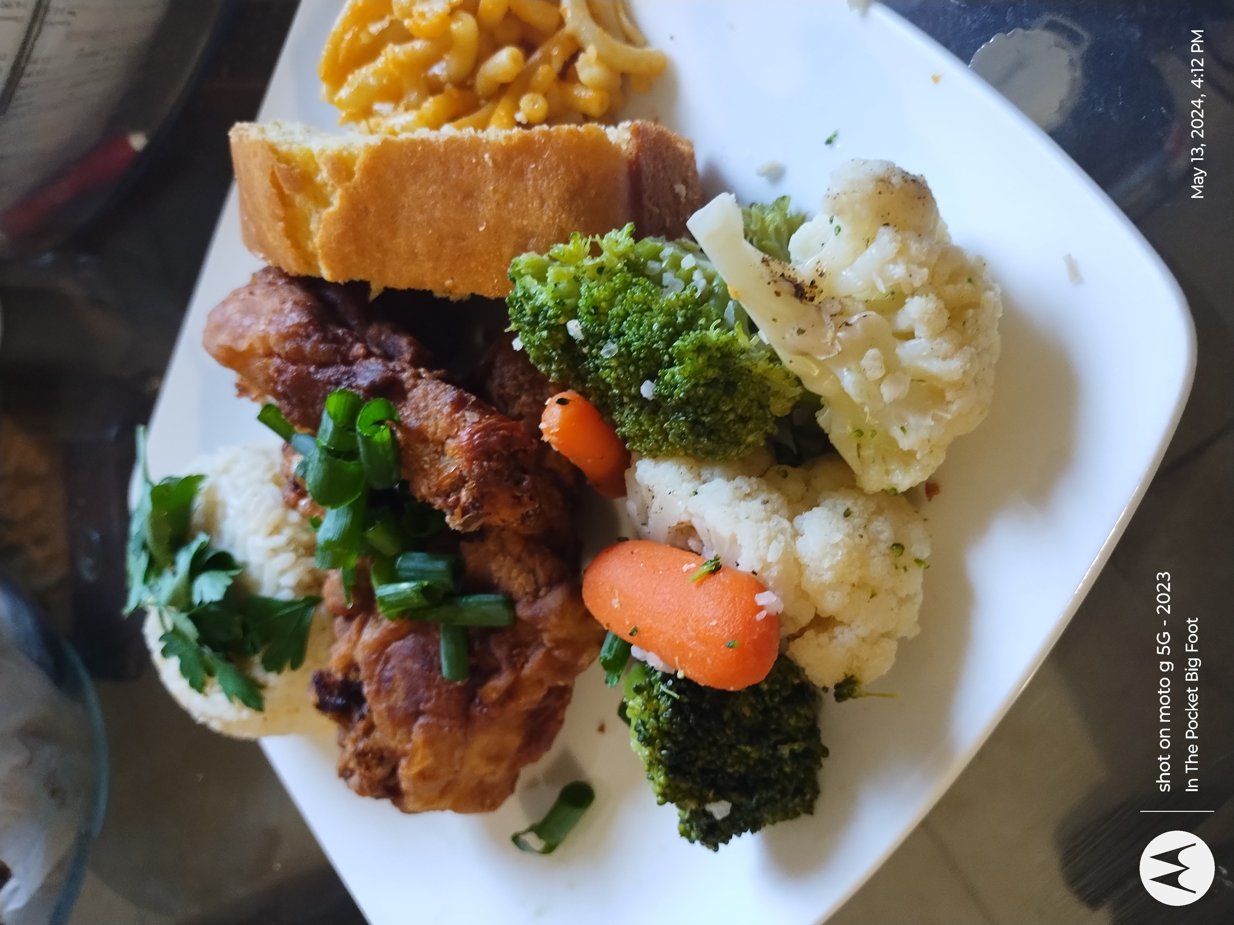 Dinner dish Fried chicken legs carrots cornbread broccoli macaroni and cheese.