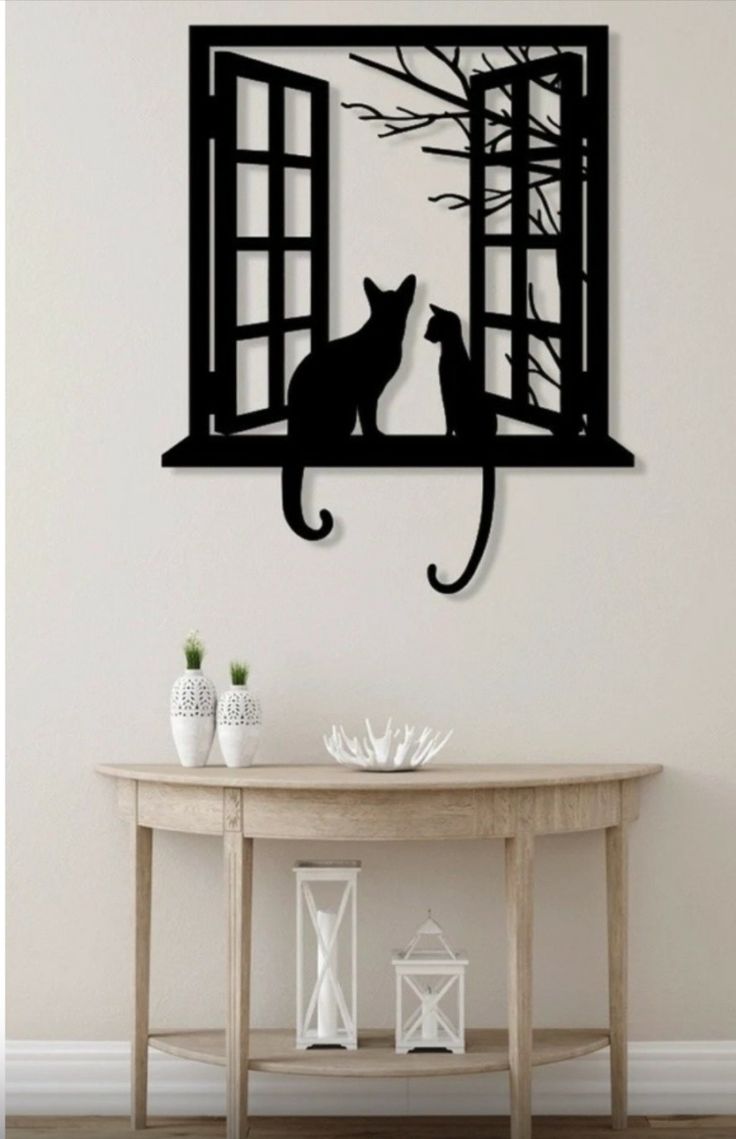 Escultura de pared de gatos en la ventana