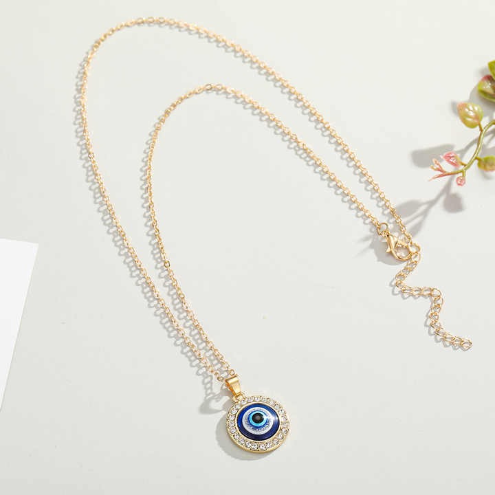 Protective blue evil eye pendant necklace with shiny diamond detail, silver link chain, pearl accent, and leather cord — a perfect stylish gift for any occasion.