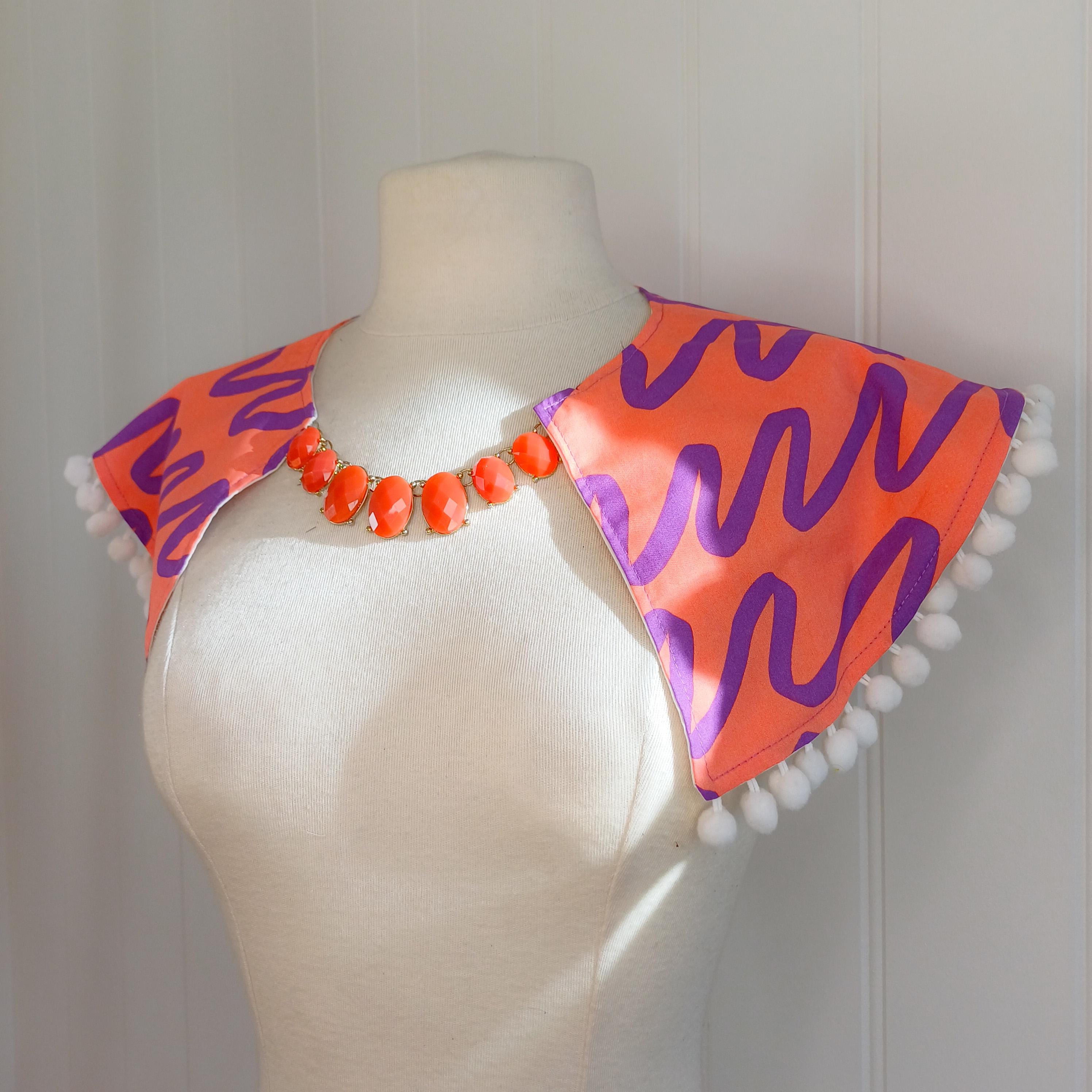 Bold print collar with pompom trim