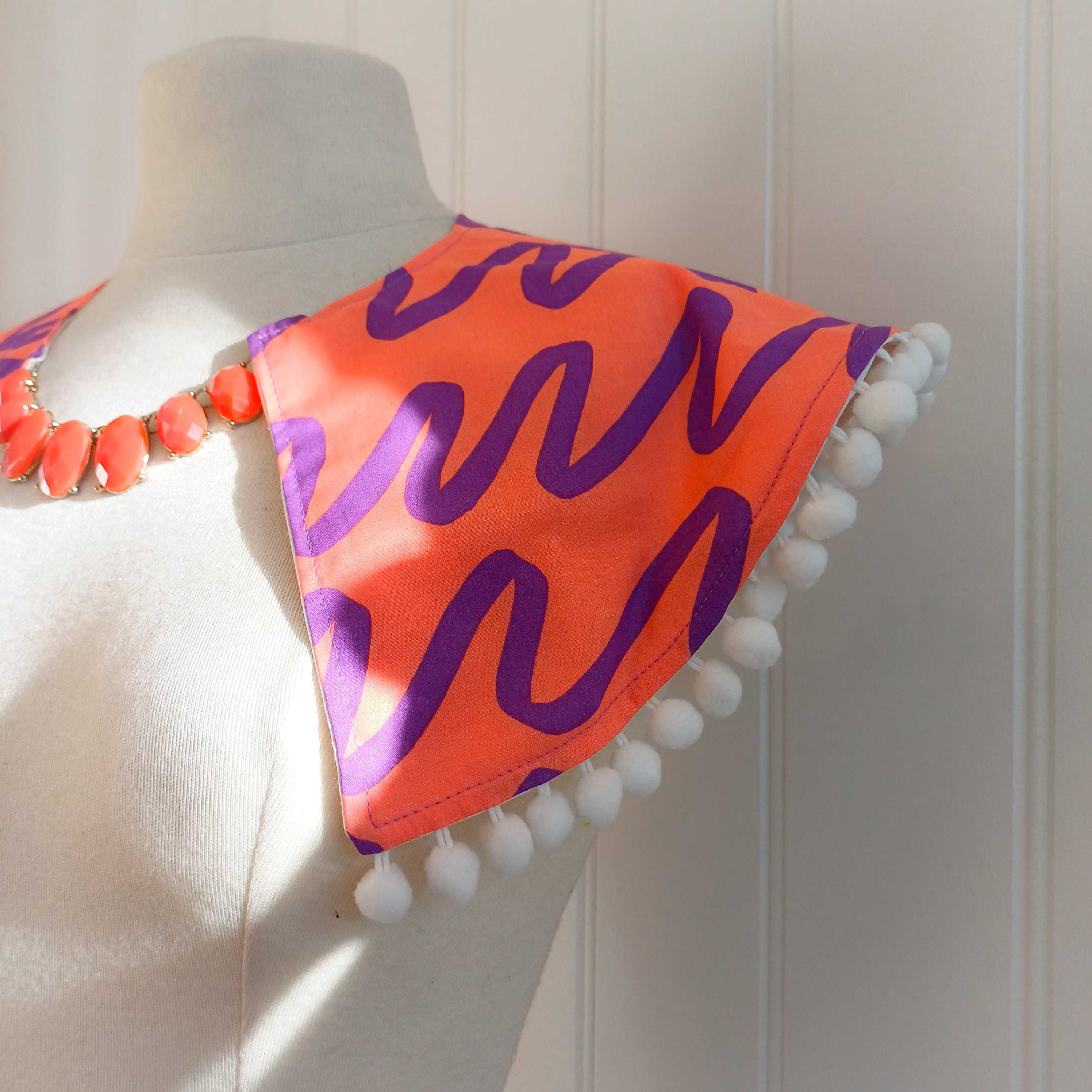 Bold print collar with pompom trim