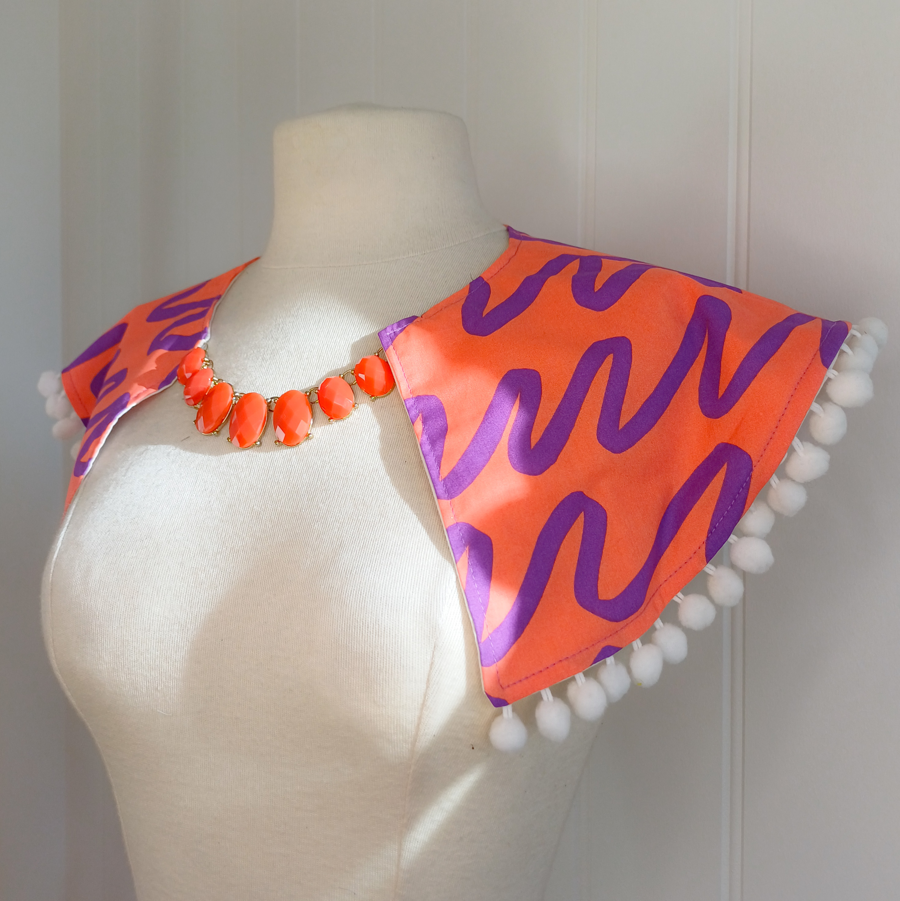 Bold print collar with pompom trim
