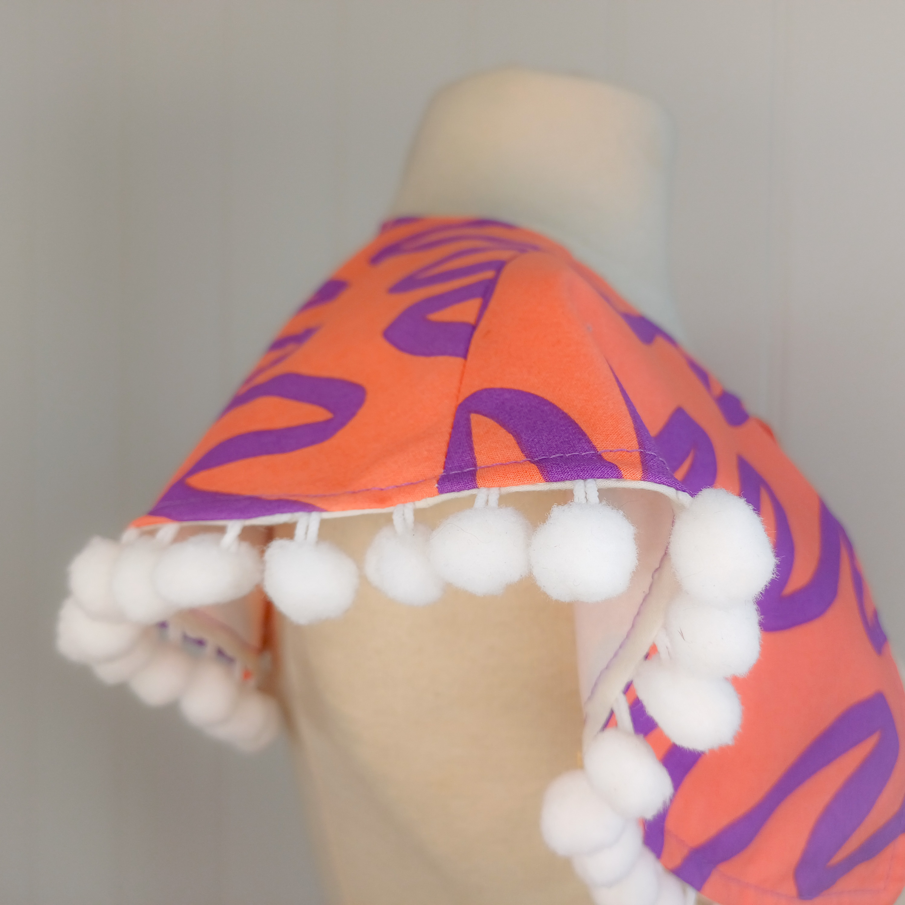 Bold print collar with pompom trim