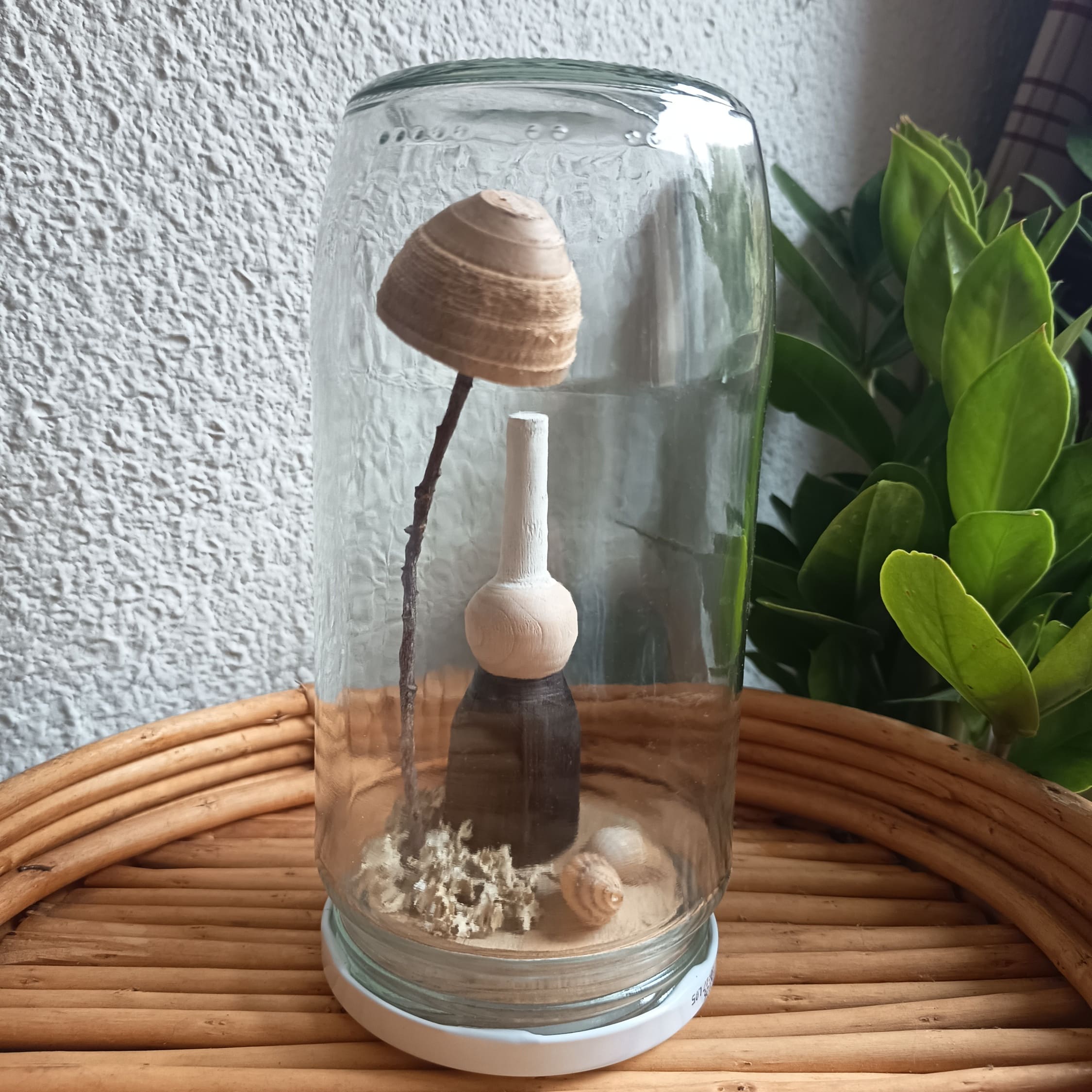 Bigoudène en bois dans un bocal en verre.