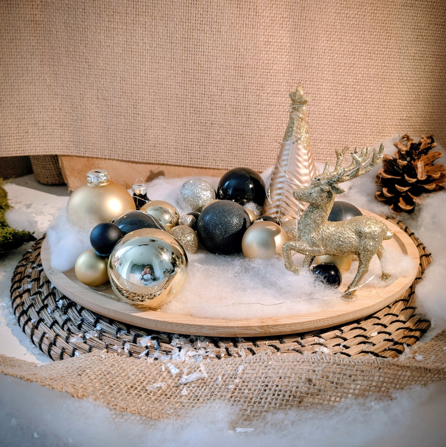 Christmas Deko im zeitlosen gold-schwarz auf einem ovalen Holztablett