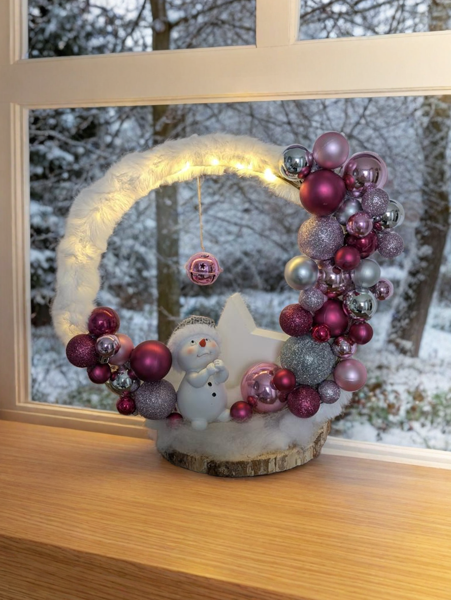 Weihnachtlicher Loop beleuchtet auf Birkenholz als Standfuß, mit Schneemann und großem Stern und Kugeln in zartem Rosa, elegantem Silber und edlem Violett