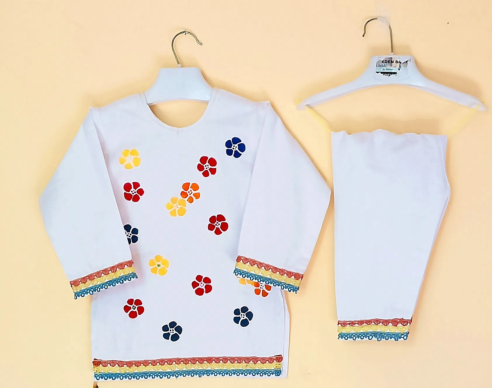 Rainbow Bloom Experience the beauty of handcrafted artistry. This shalwar kameez features delicate, hand-painted flowers that capture the essence of nature.