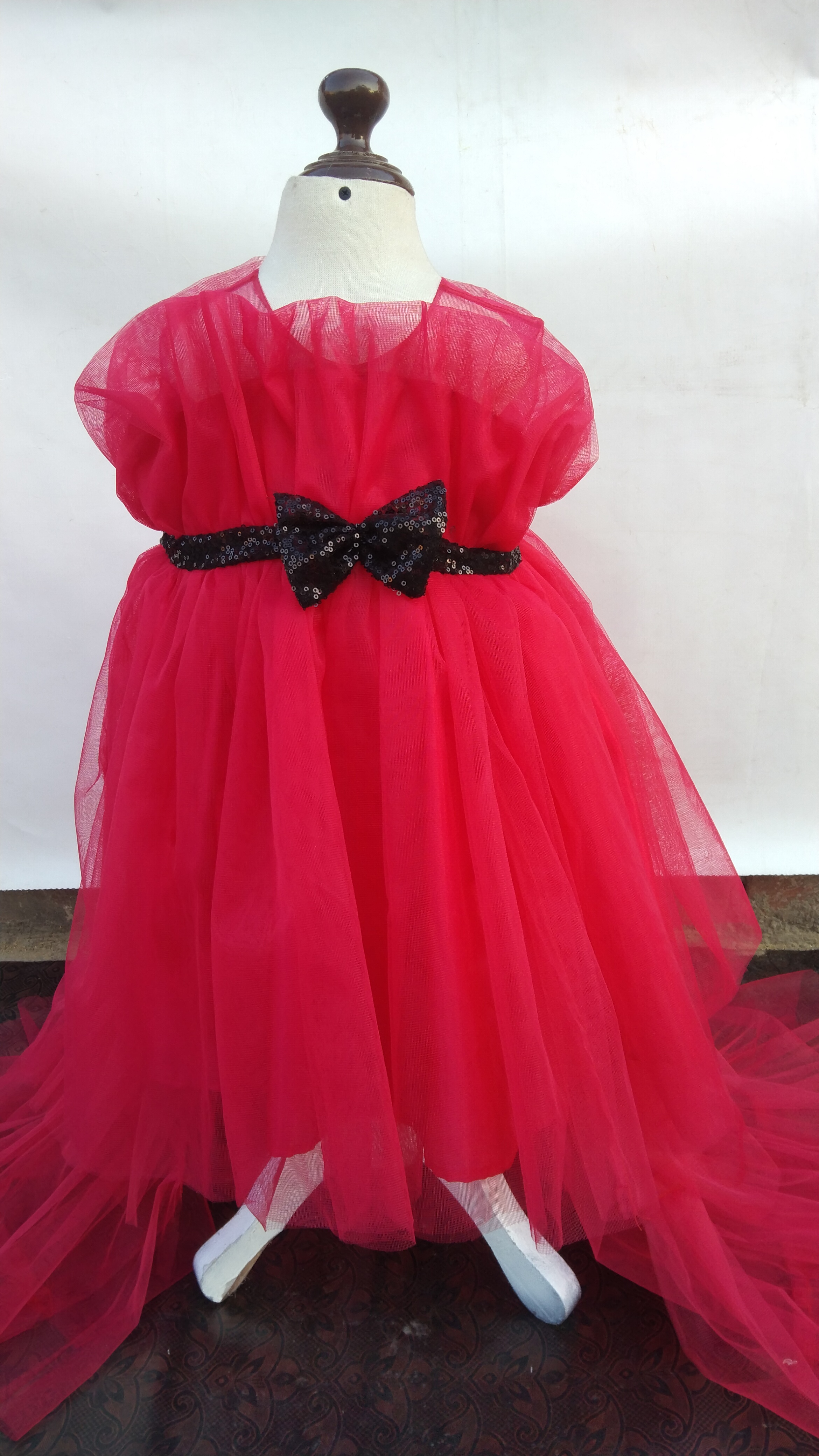 Candy Floss Cascade, The "Candy Floss Cascade" baby girls dress is a Barbie pink dream. Swirling tulle, ruffles, a sequin belt, and bows create a whimsical, voluminous design perfect for twirling.