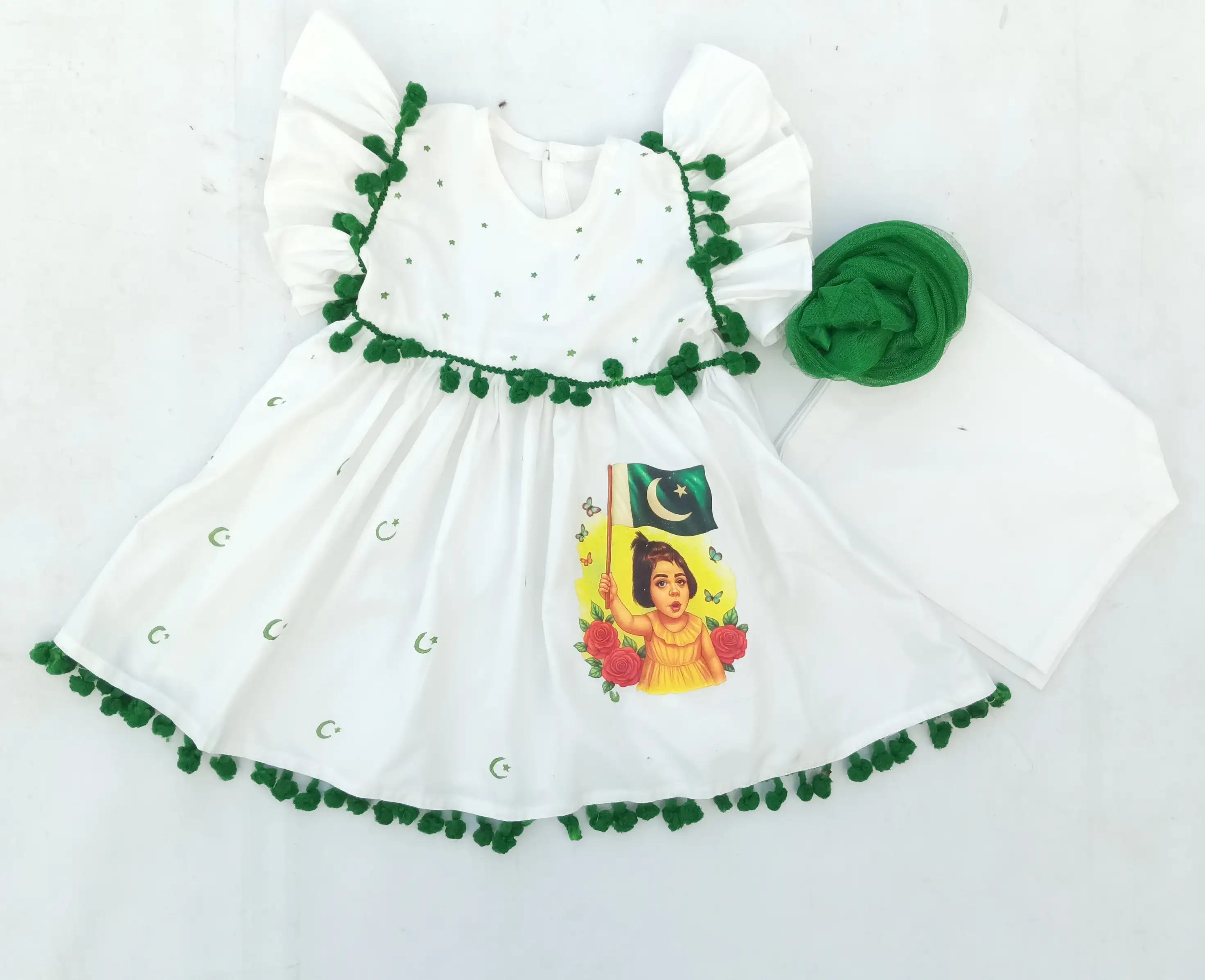 Starry Blossom Frock Patriotic Elegance for Little Hearts "A young girl in a white Pakistani Independence Day dress, holding a white flower in a garden."