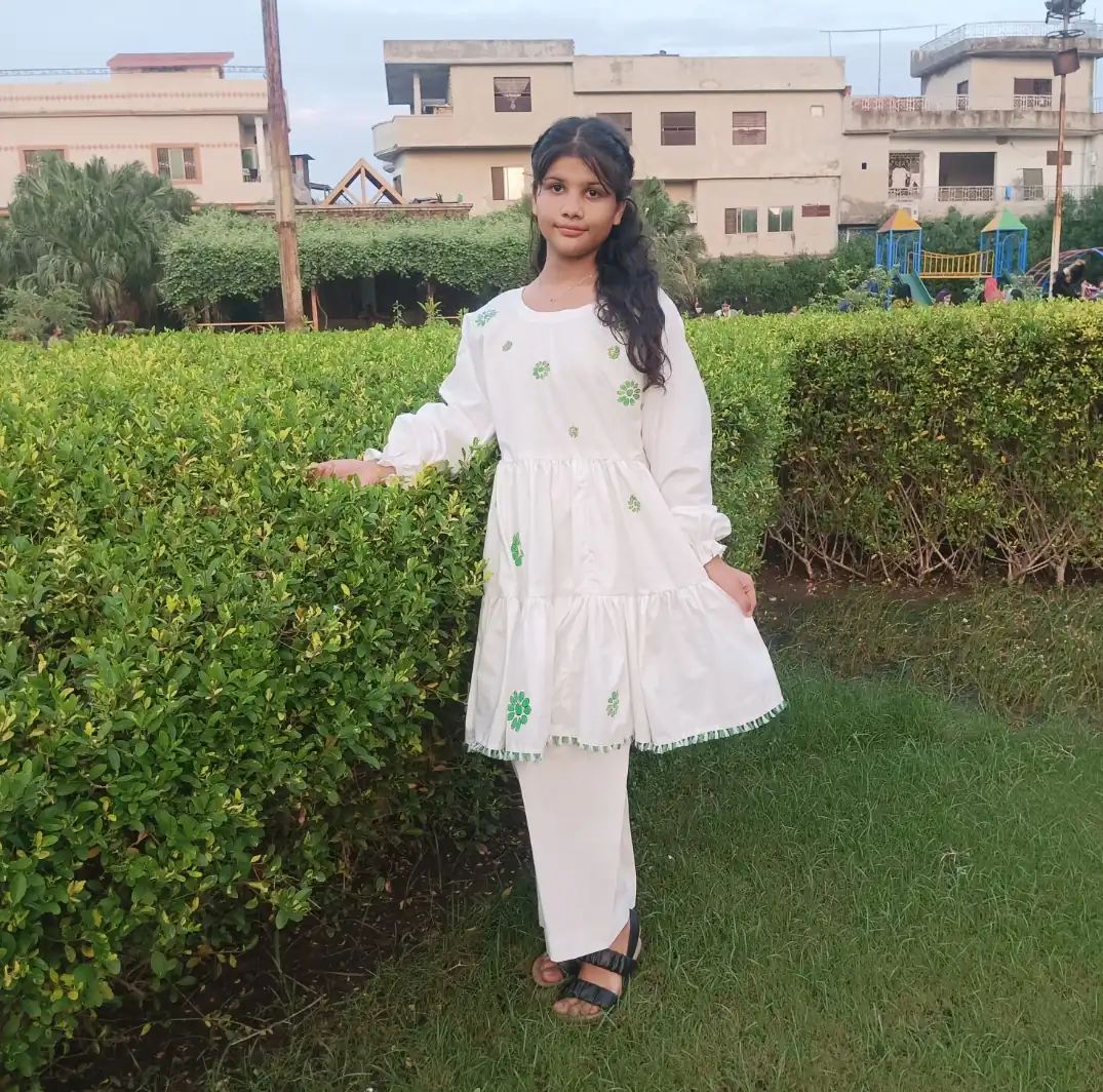 Patriotic Petals A young Pakistani girl in a white and green hand-painted frock and trouser set, an outfit for Pakistan's Independence Day.