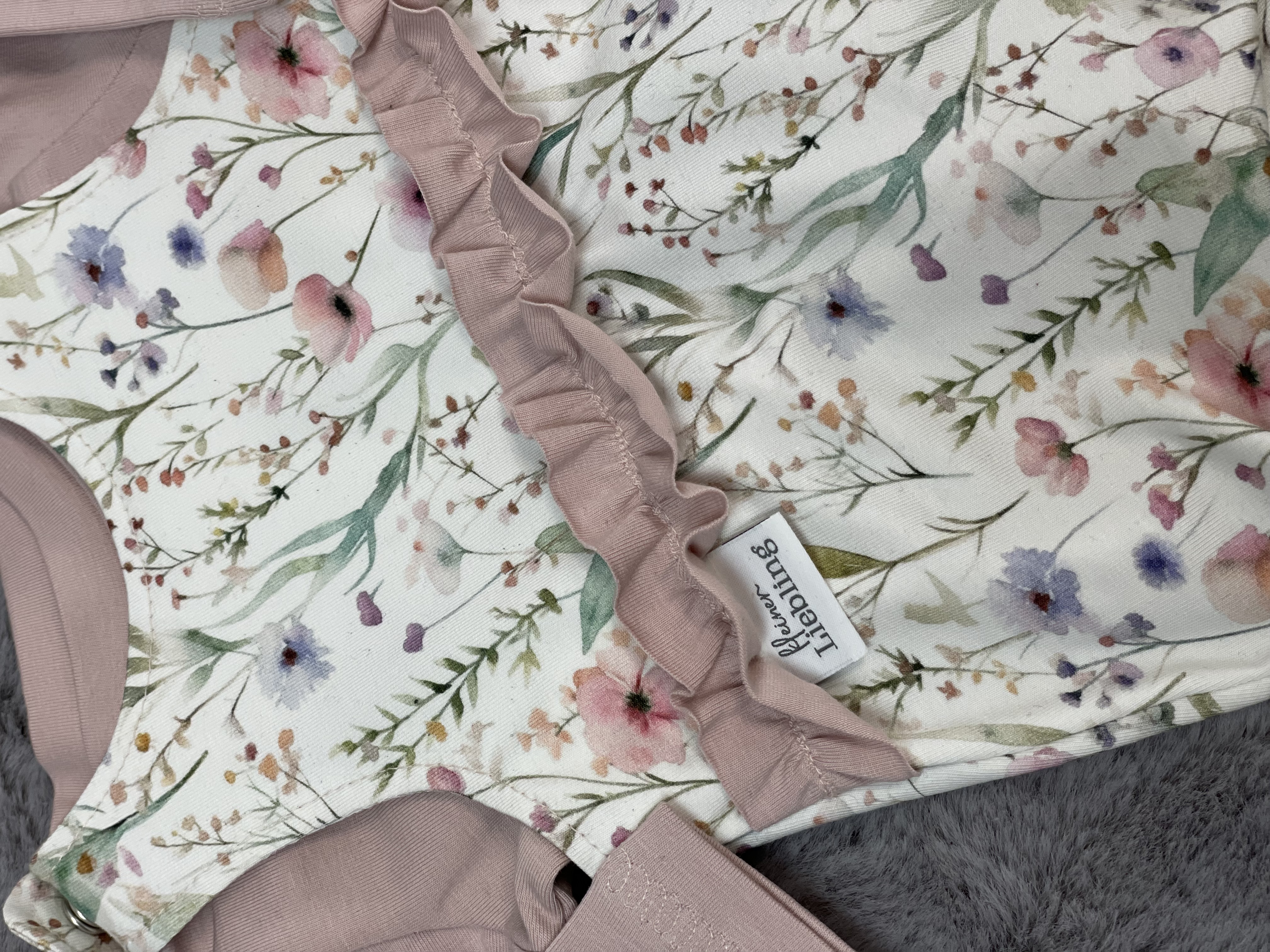 Newborn Strampler mit Blumen und süßen Details