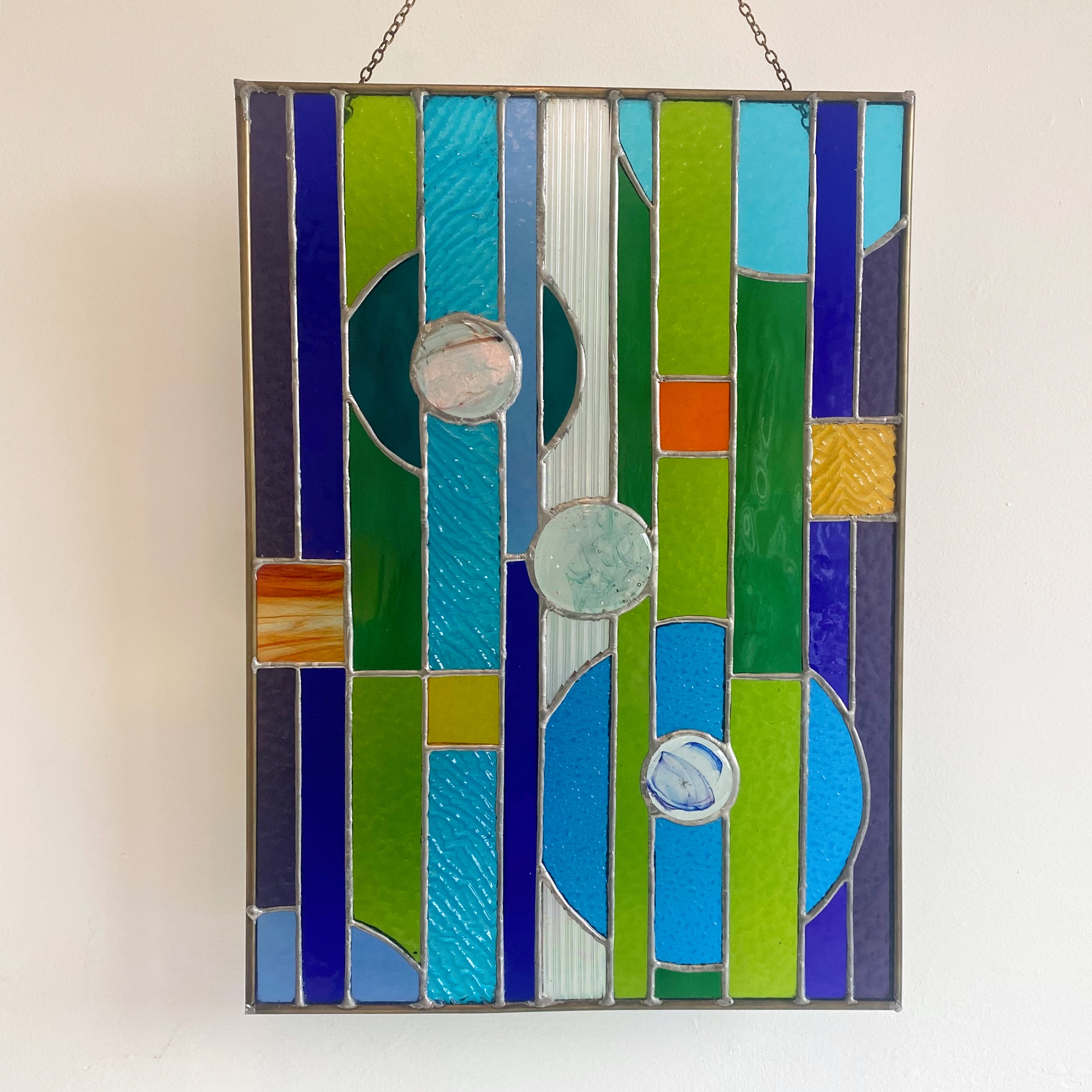 Contemporary stained glass panel with circles and stripes, with fused glass small circles.