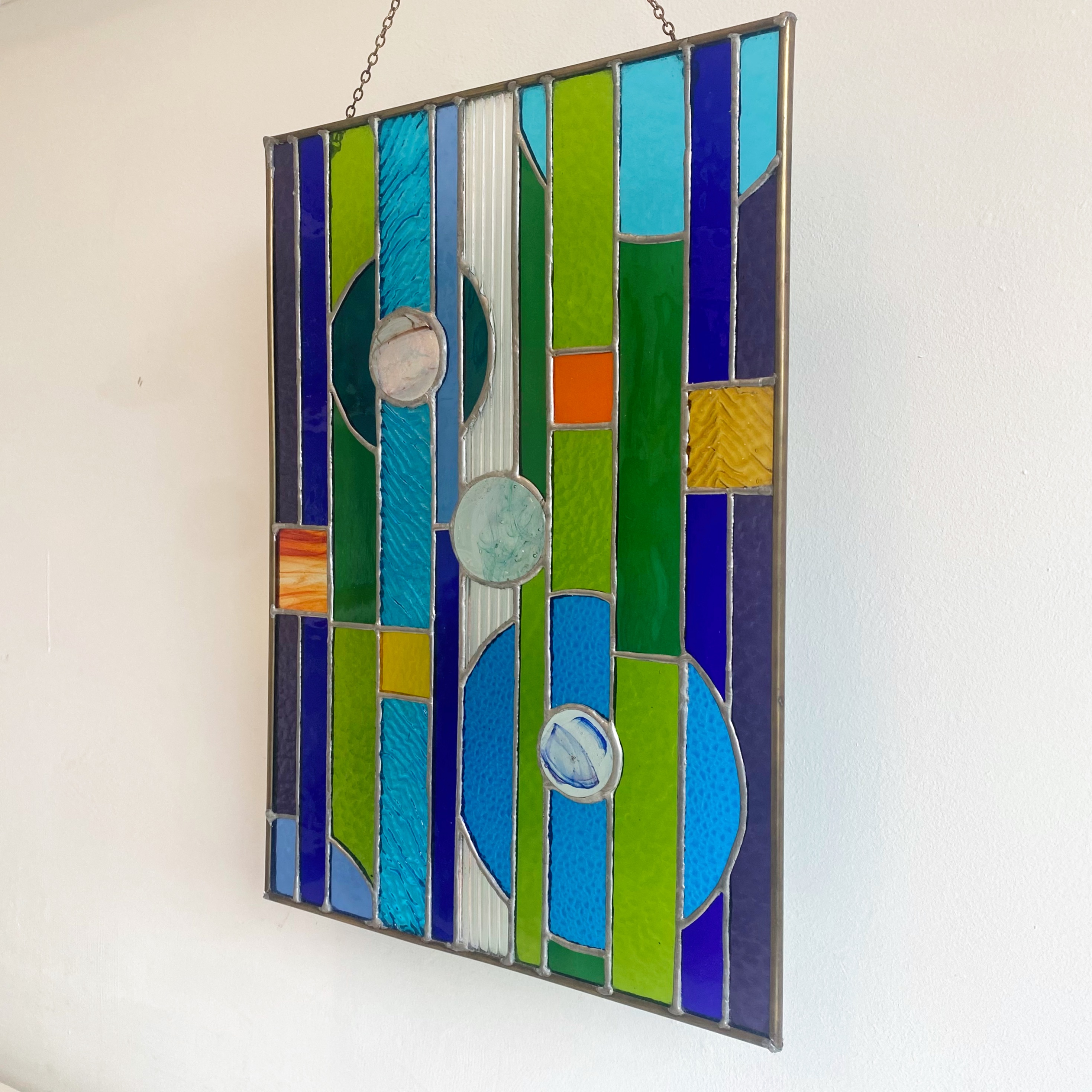 Contemporary stained glass panel with circles and stripes, with fused glass small circles.