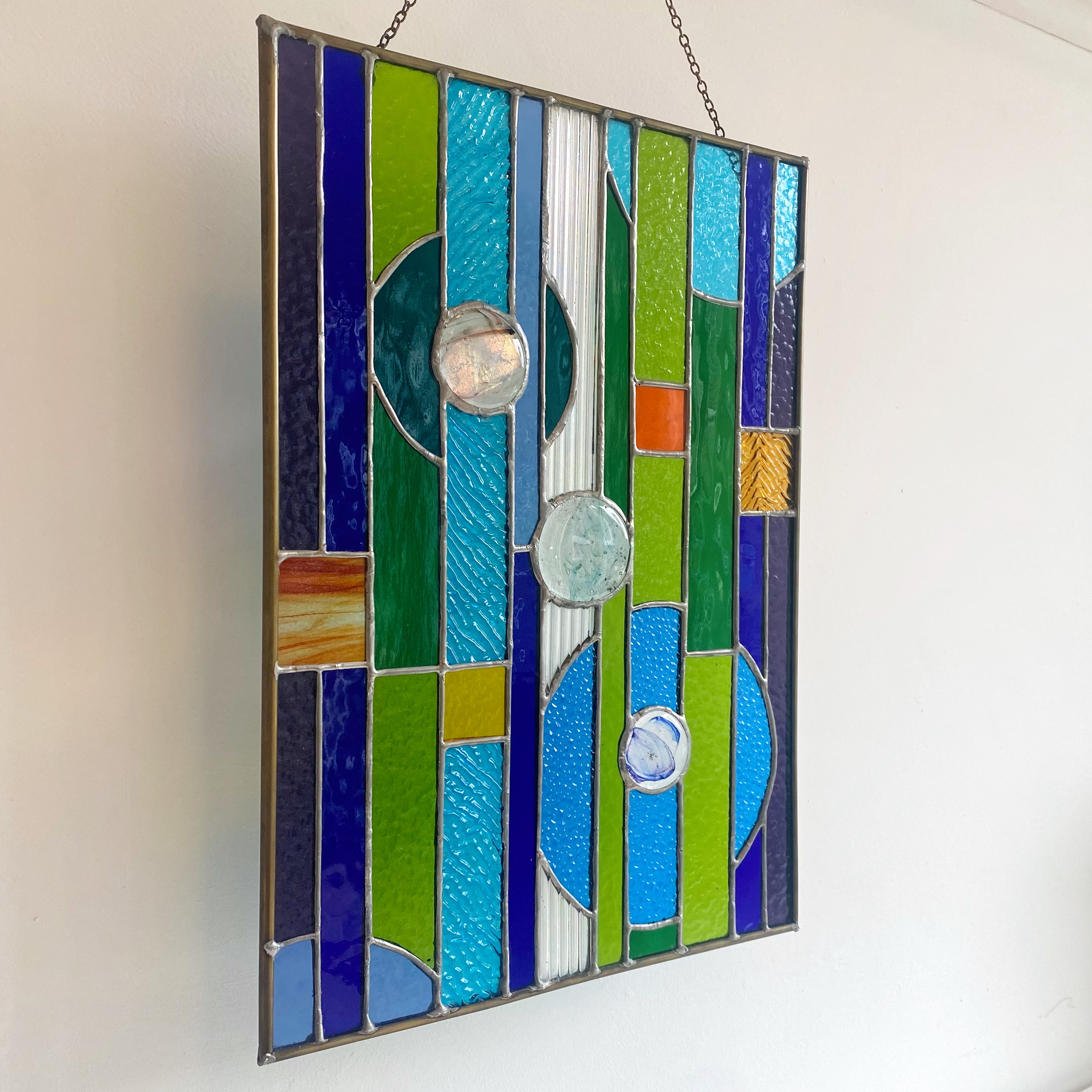 Contemporary stained glass panel with circles and stripes, with fused glass small circles.