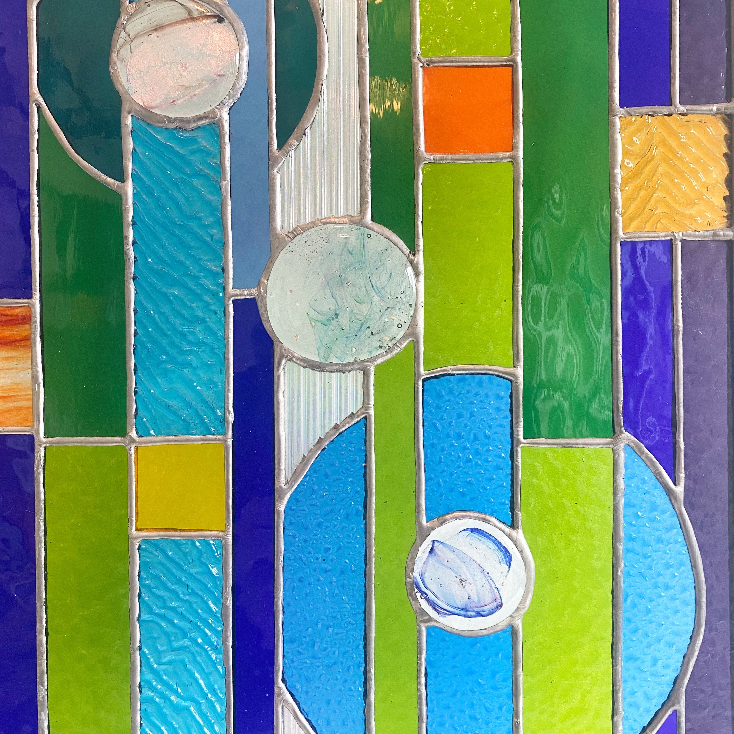 Contemporary stained glass panel with circles and stripes, with fused glass small circles.