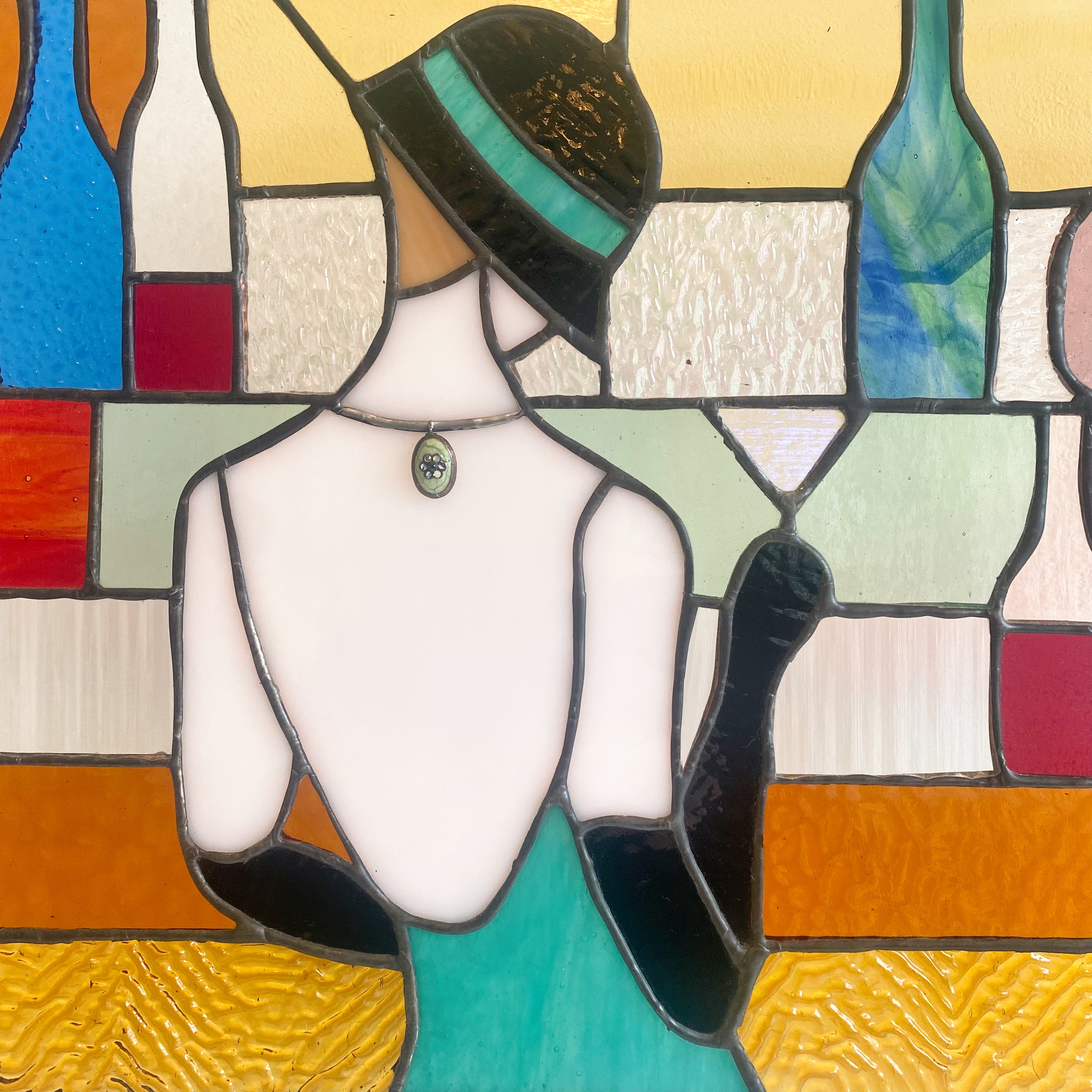 Contemporary stained glass panel with a lady stood at a bar.
