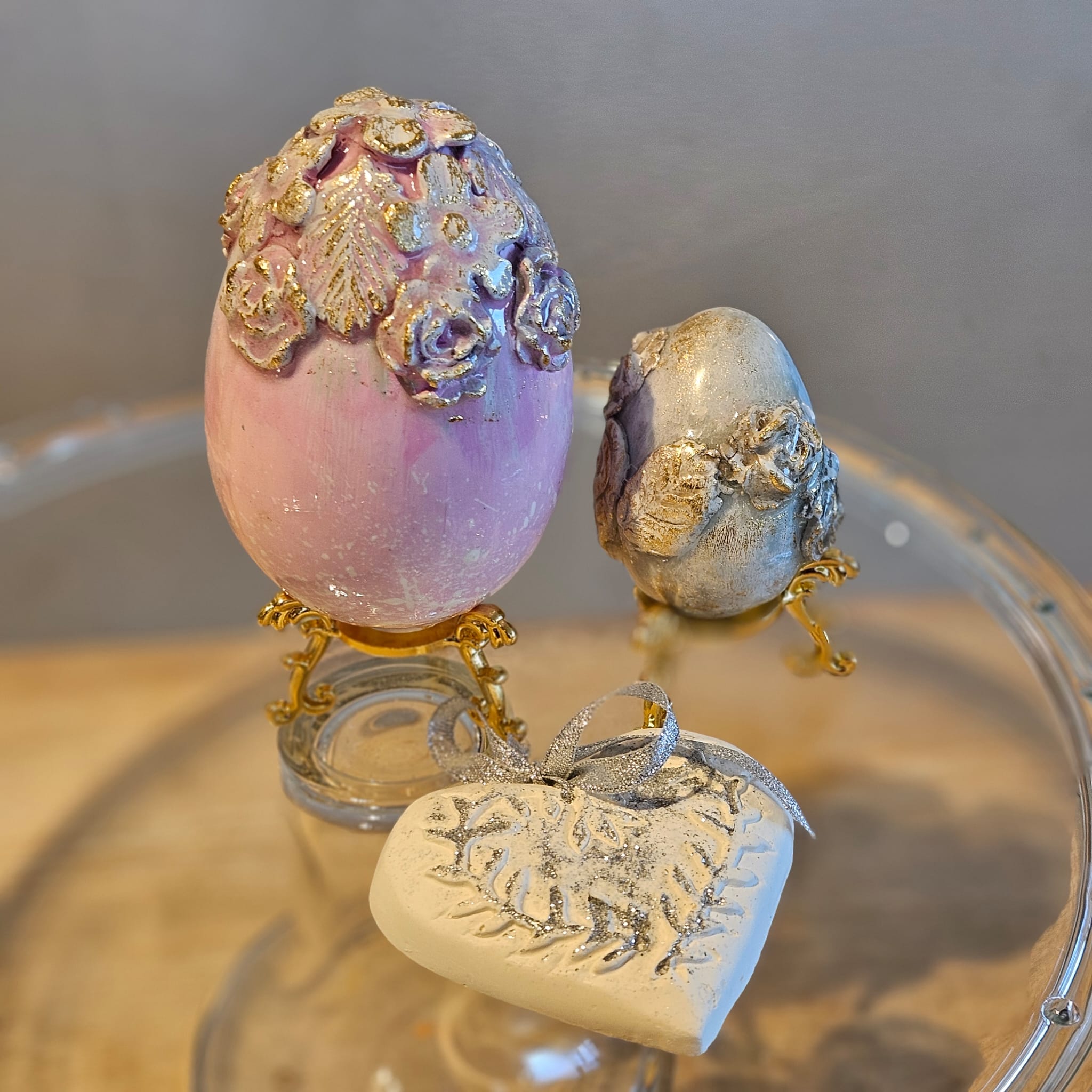 Lot de deux œufs sculptés et cœur de plâtre, supports dorés offerts