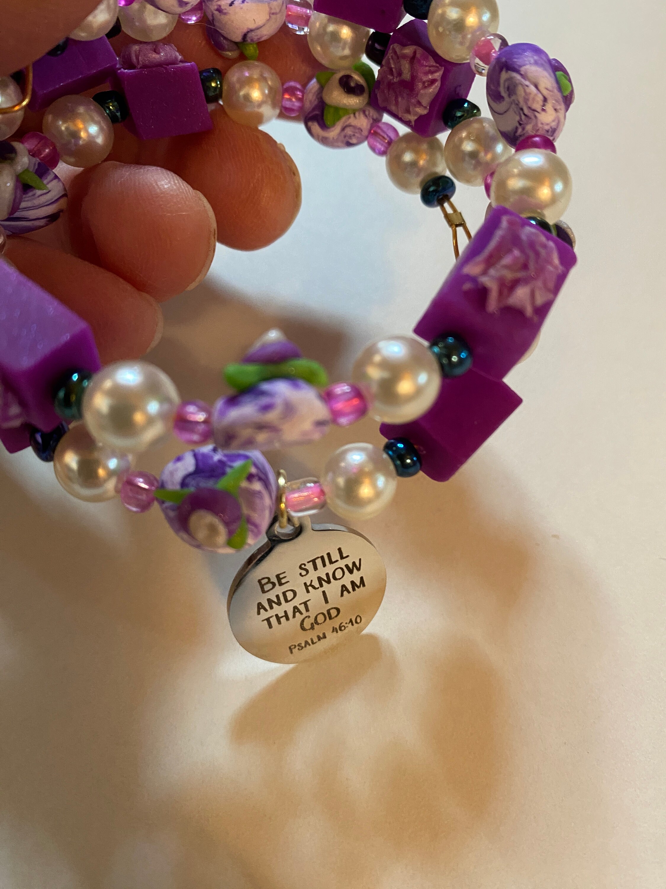 Expandable coil bracelet featuring hand crafted beads and Christian charm Be Still and Know that I Am God, includes matching earrings