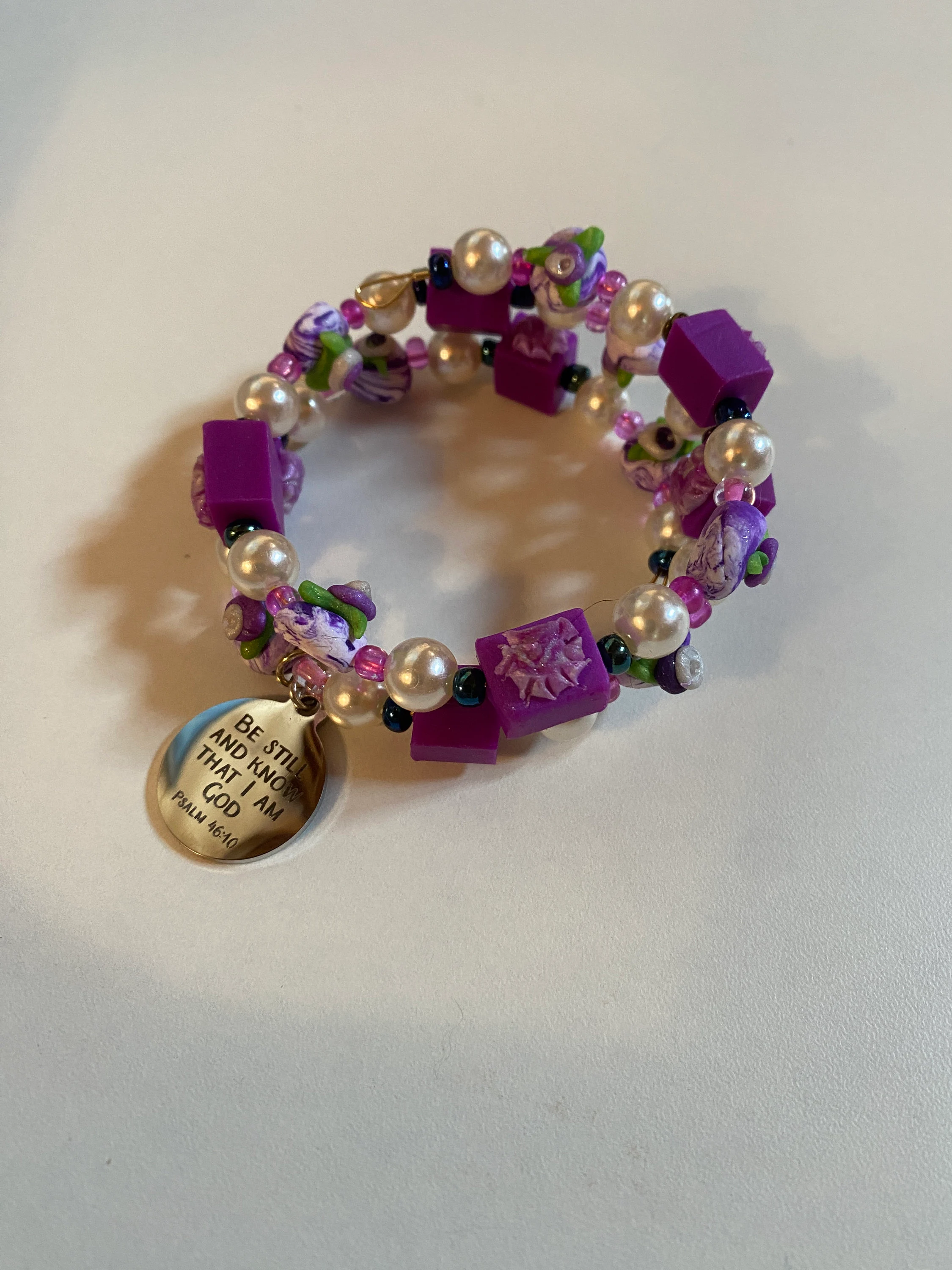 Expandable coil bracelet featuring hand crafted beads and Christian charm Be Still and Know that I Am God, includes matching earrings