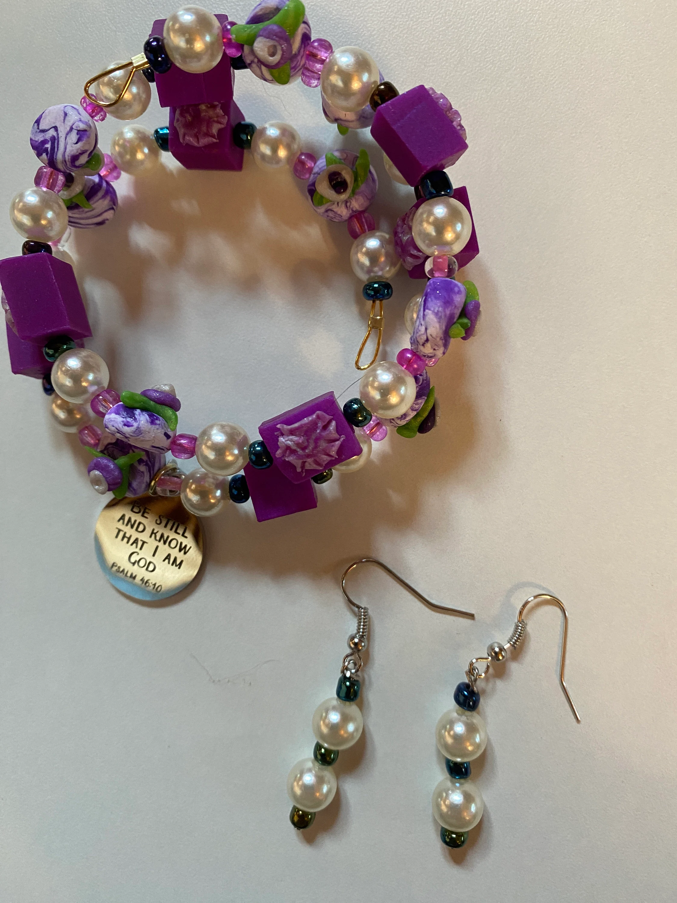 Expandable coil bracelet featuring hand crafted beads and Christian charm Be Still and Know that I Am God, includes matching earrings