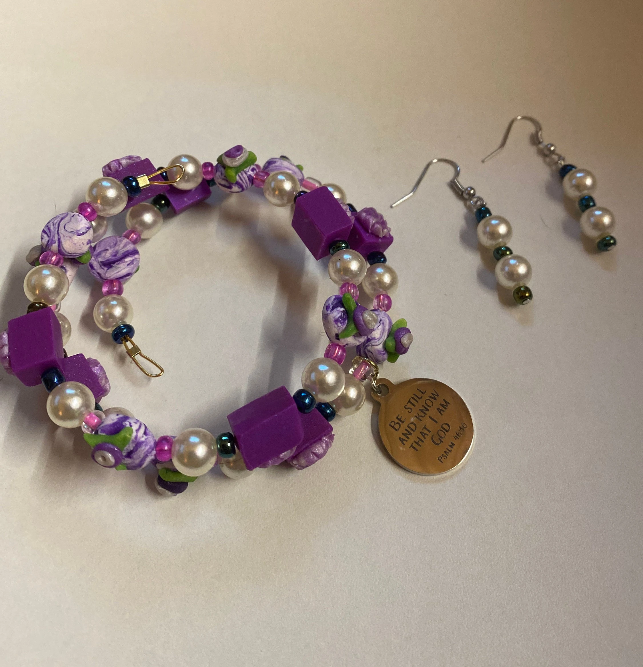 Expandable coil bracelet featuring hand crafted beads and Christian charm Be Still and Know that I Am God, includes matching earrings