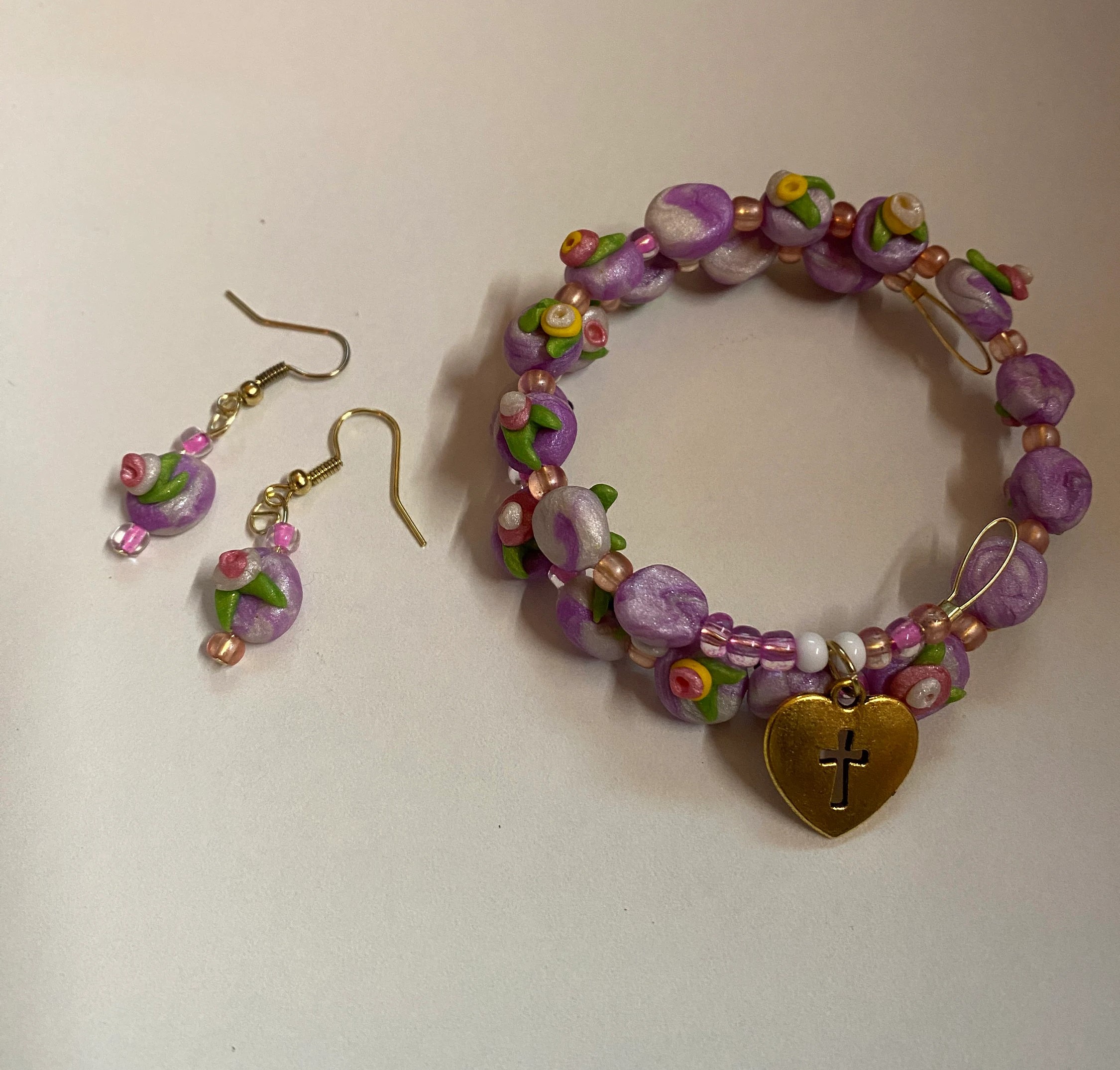 Expandable coil bracelet featuring hand crafted beads and a Christian cross heart charm, unique Christian gift, includes matching earrings