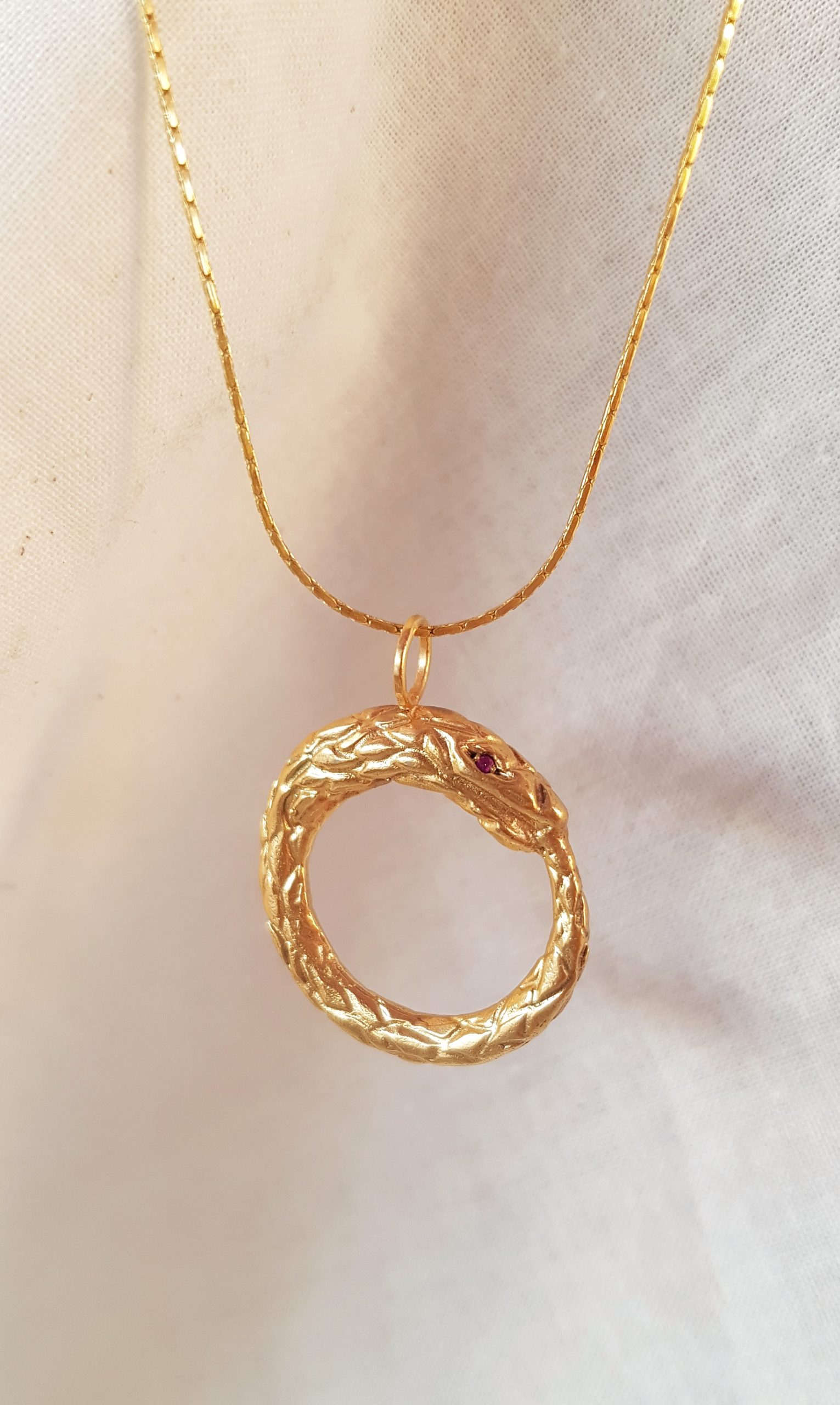 Colgante Ouroboros baño de oro y ojos rubí