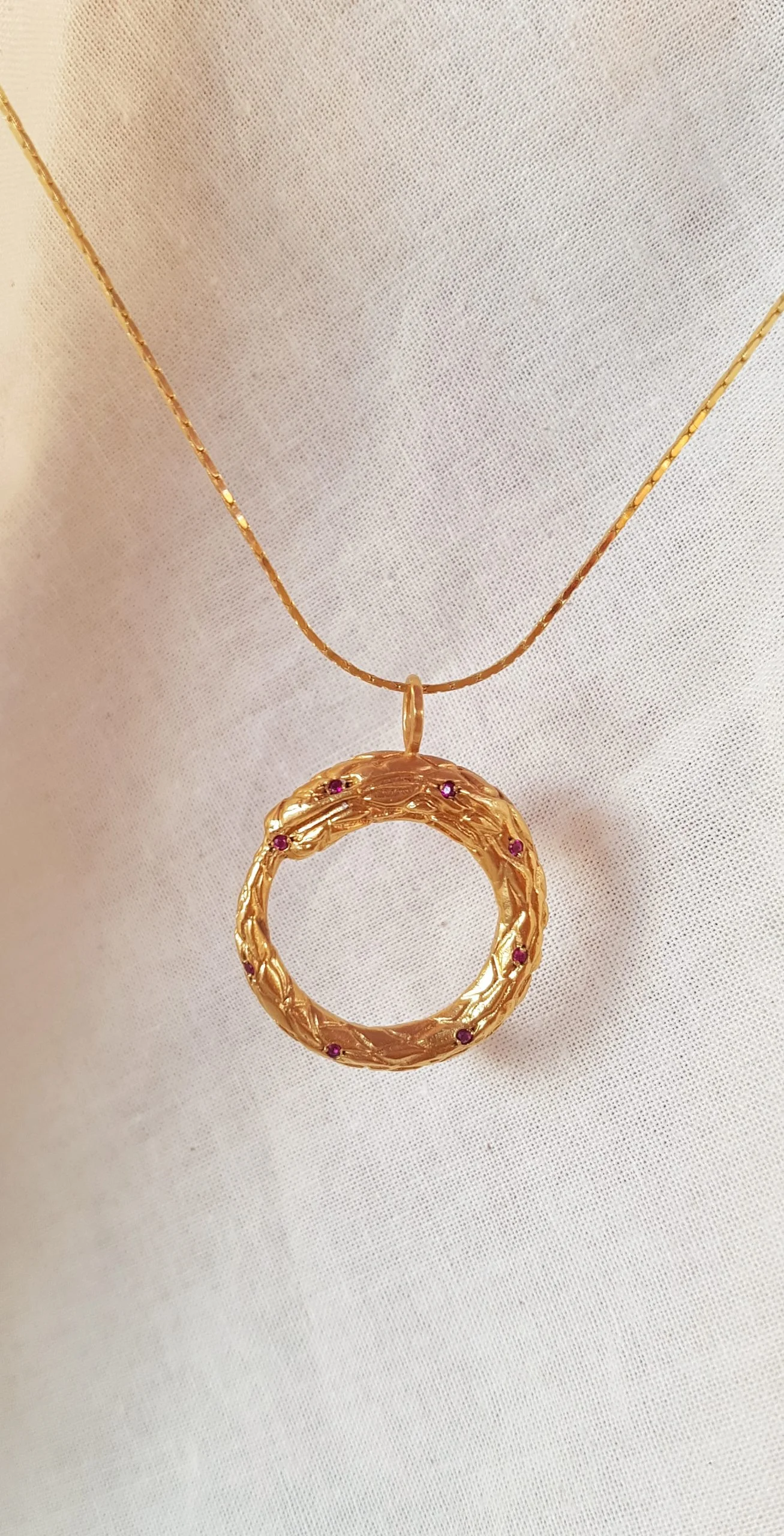 Colgante Ouroboros dorado con rubíes