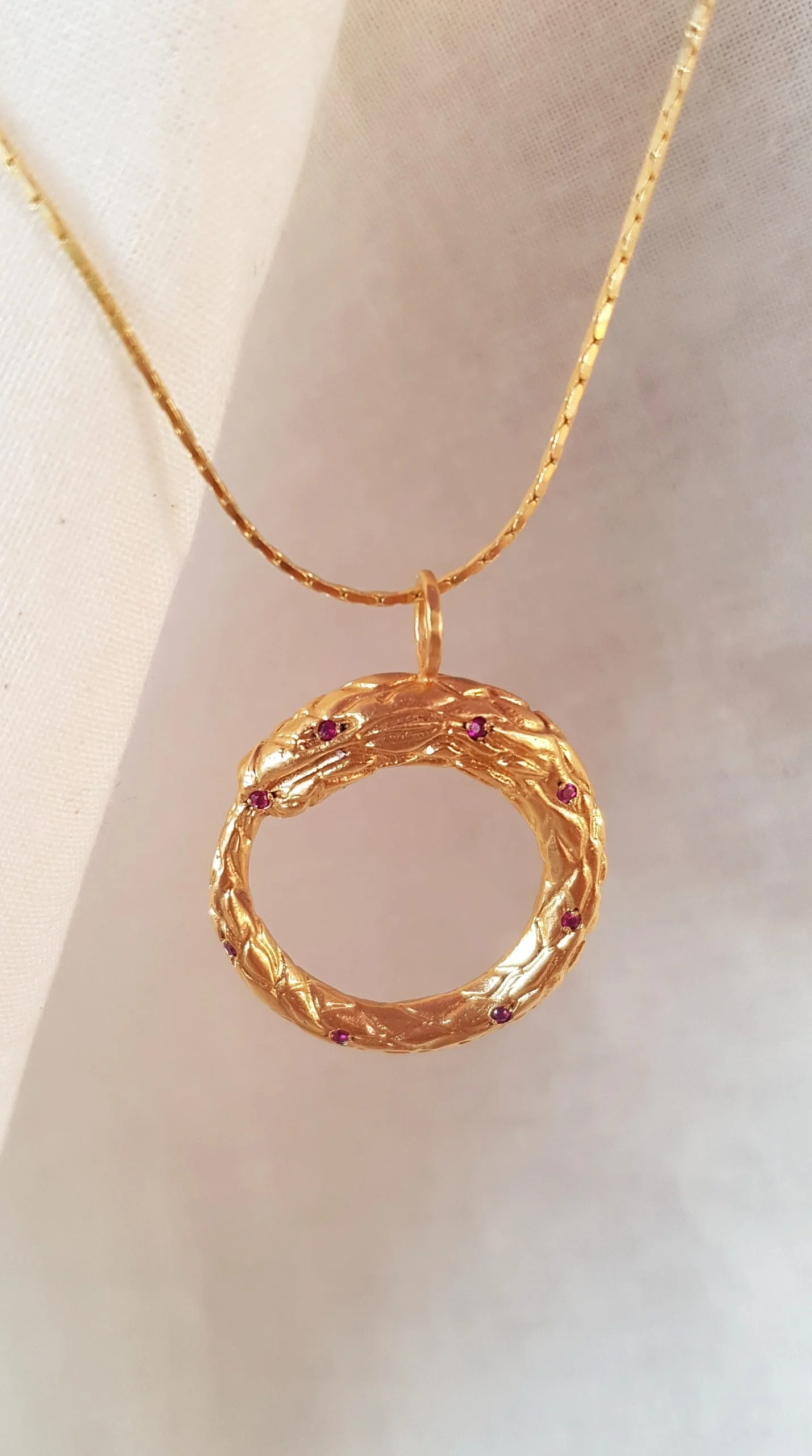 Colgante Ouroboros dorado con rubíes