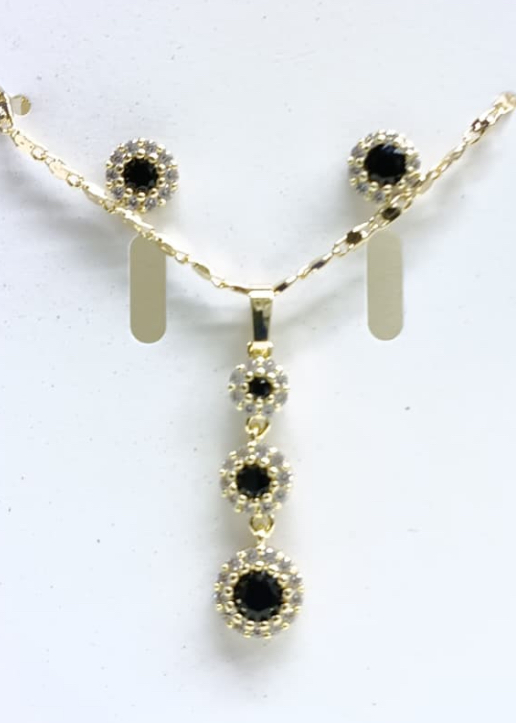 Conjunto de joyería dorada con piedras negras