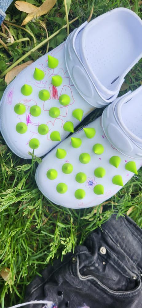 White sandals with green spikes
