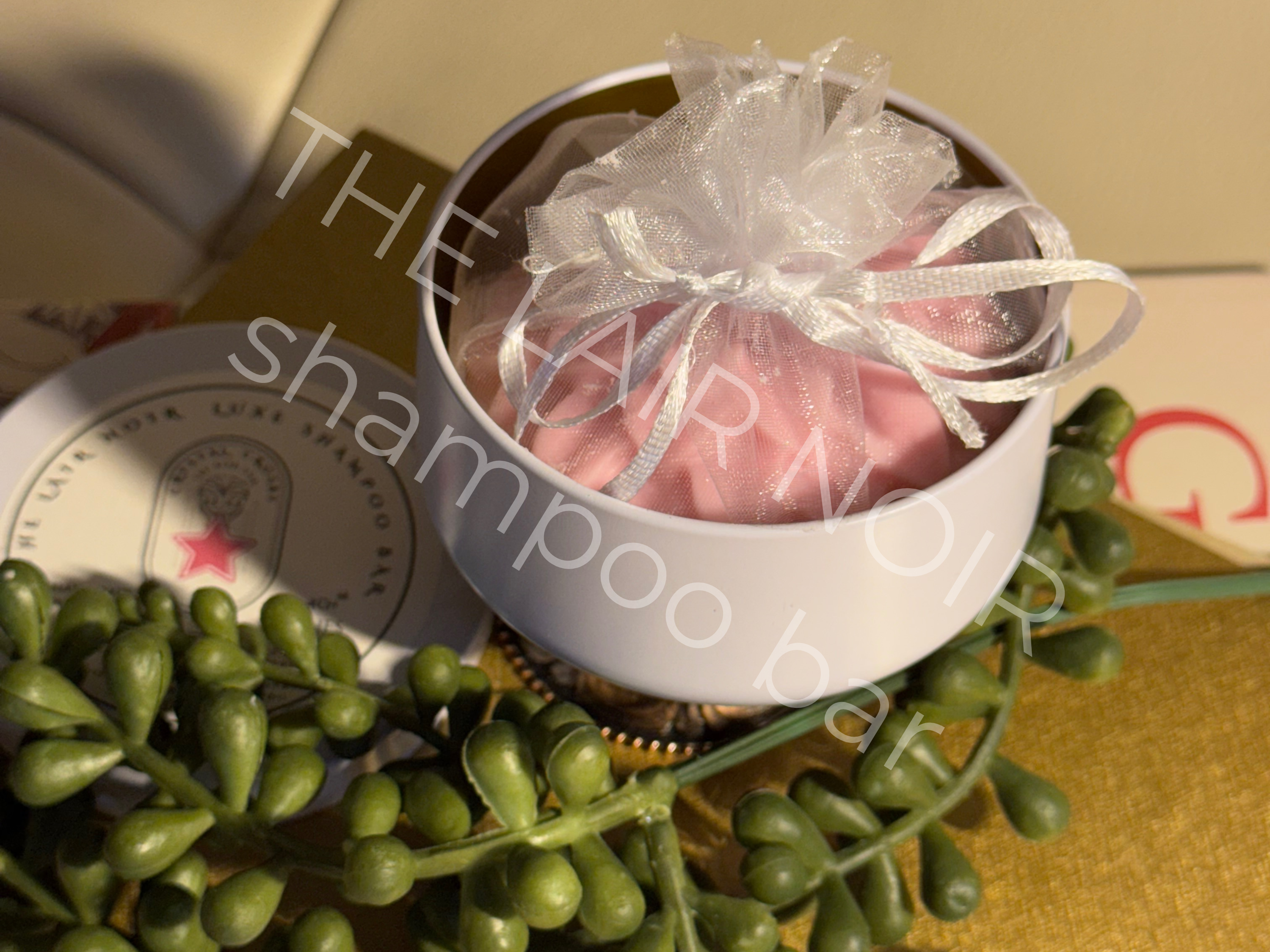 The OG (light pink) The Lair Noir Shampoo Bar created to address the appearance of thinning and overstressed tresses.